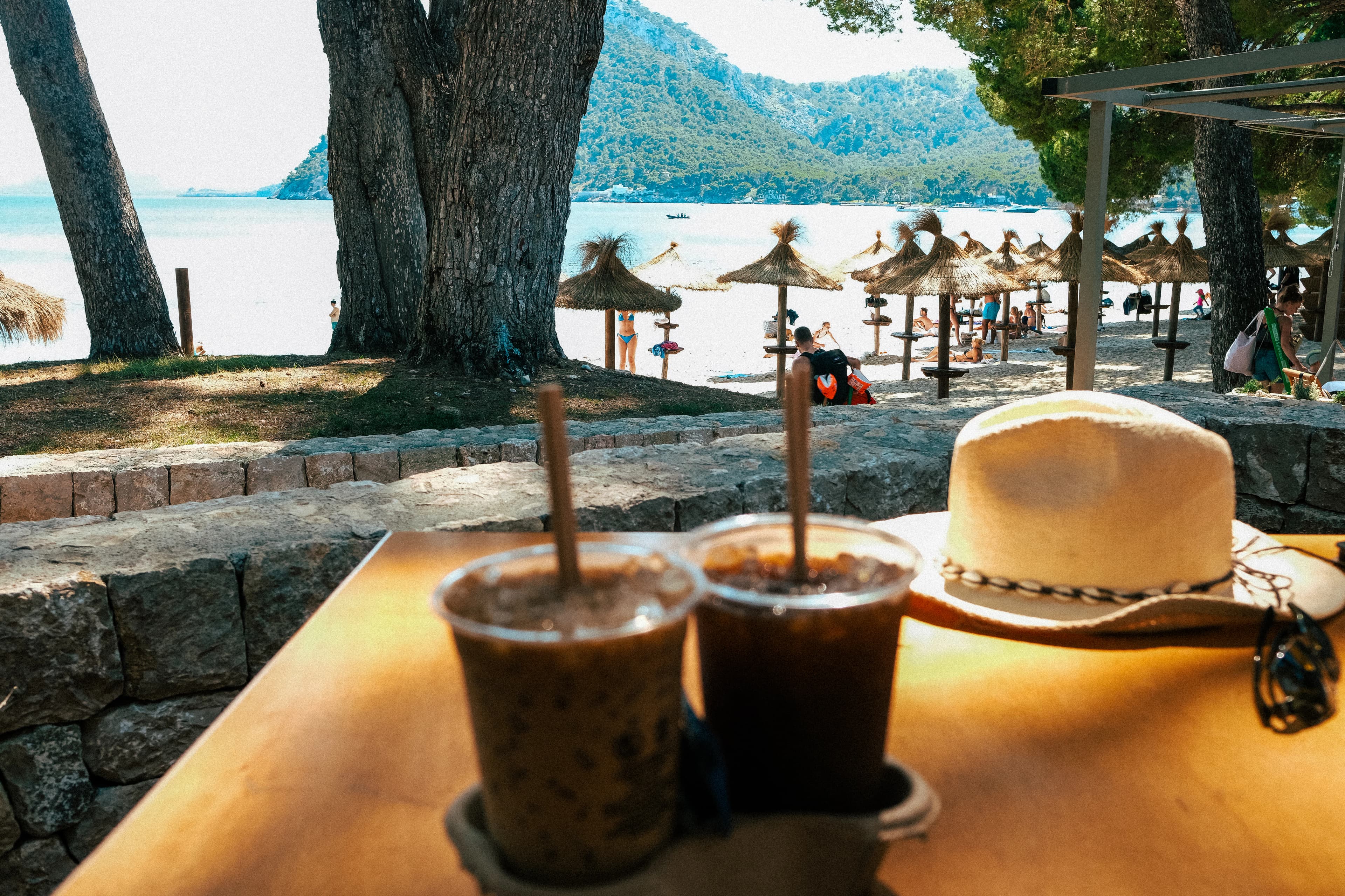 a table with two drinks and a hat on it