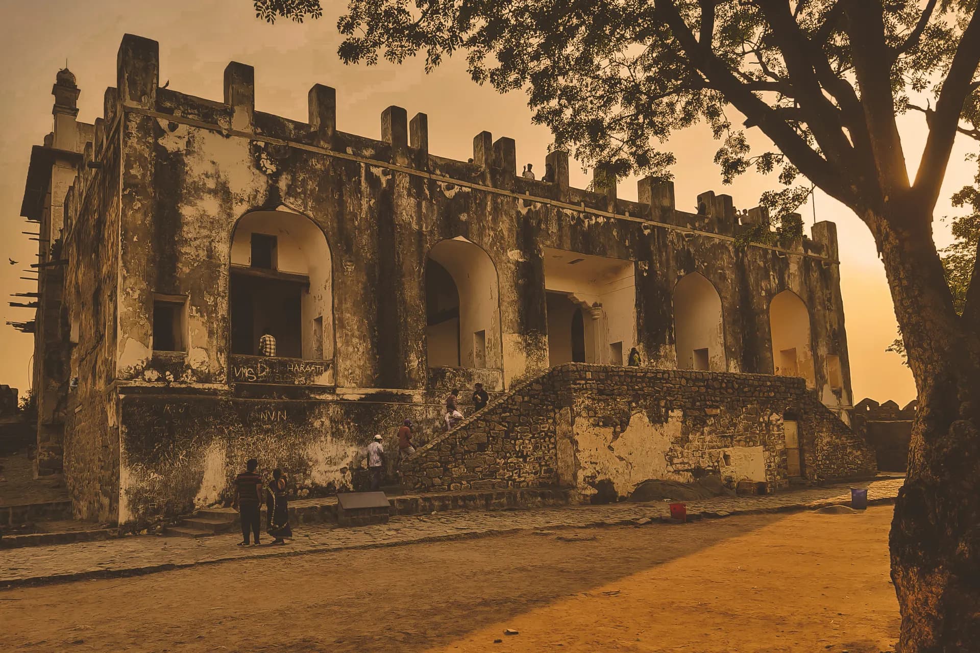 Old stone building stands beneath a warm sunset.