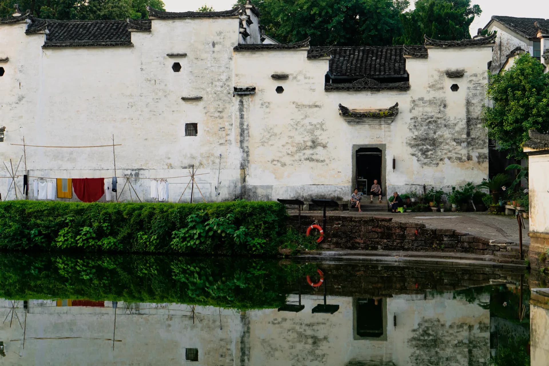 an old building with a pond in front of it