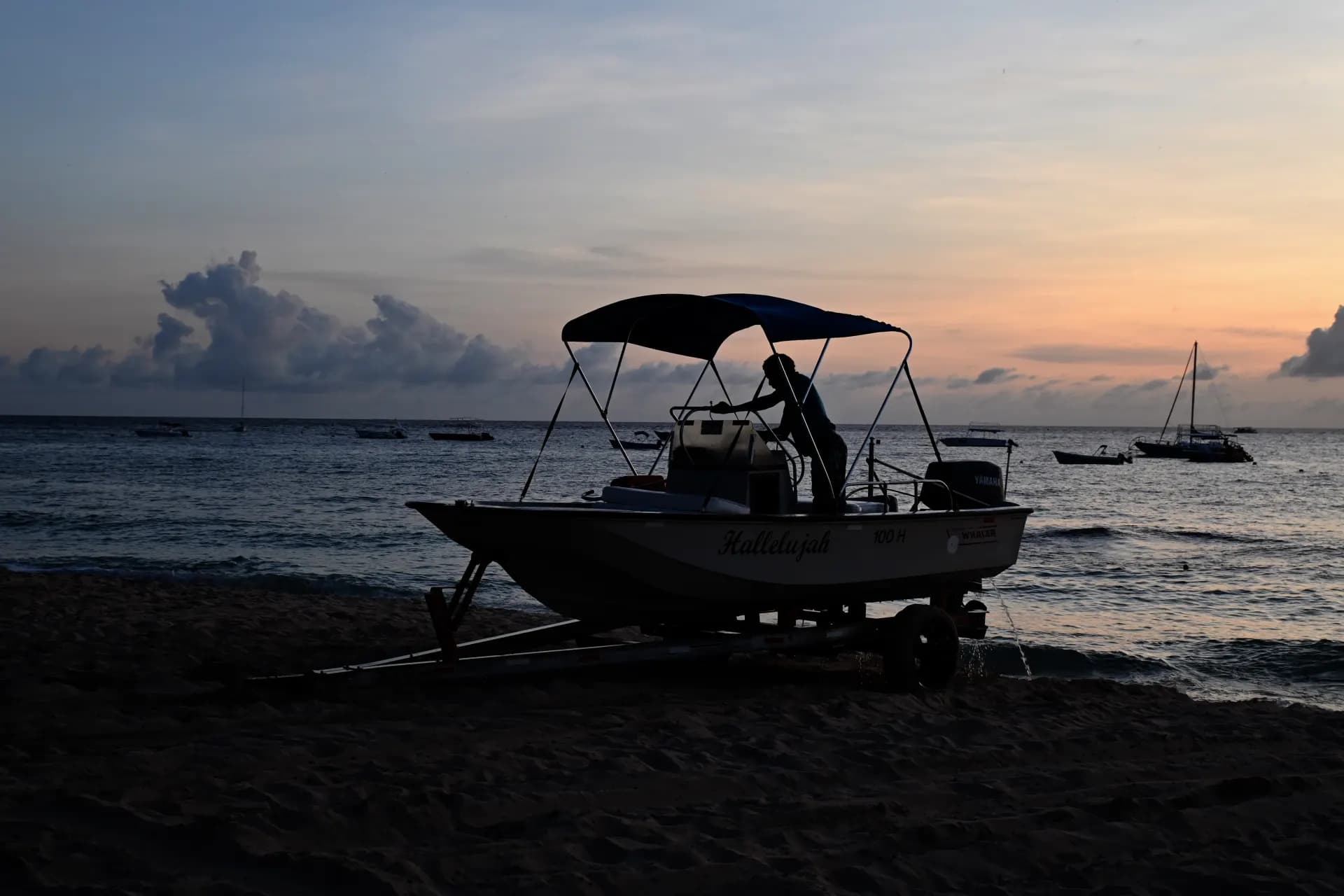 a boat sitting on top of a beach next to the ocean