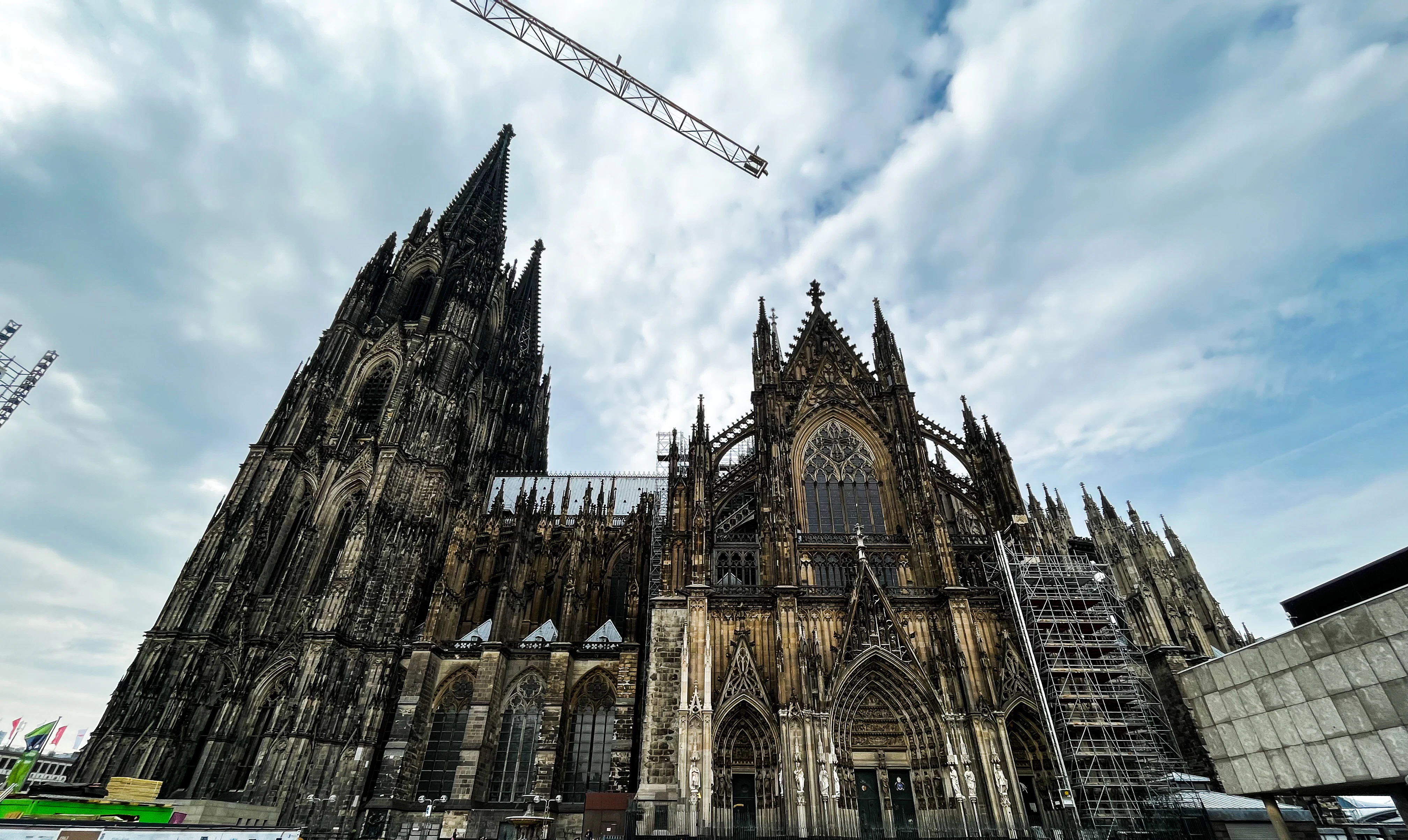 a large building under construction with Cologne Cathedral in the background