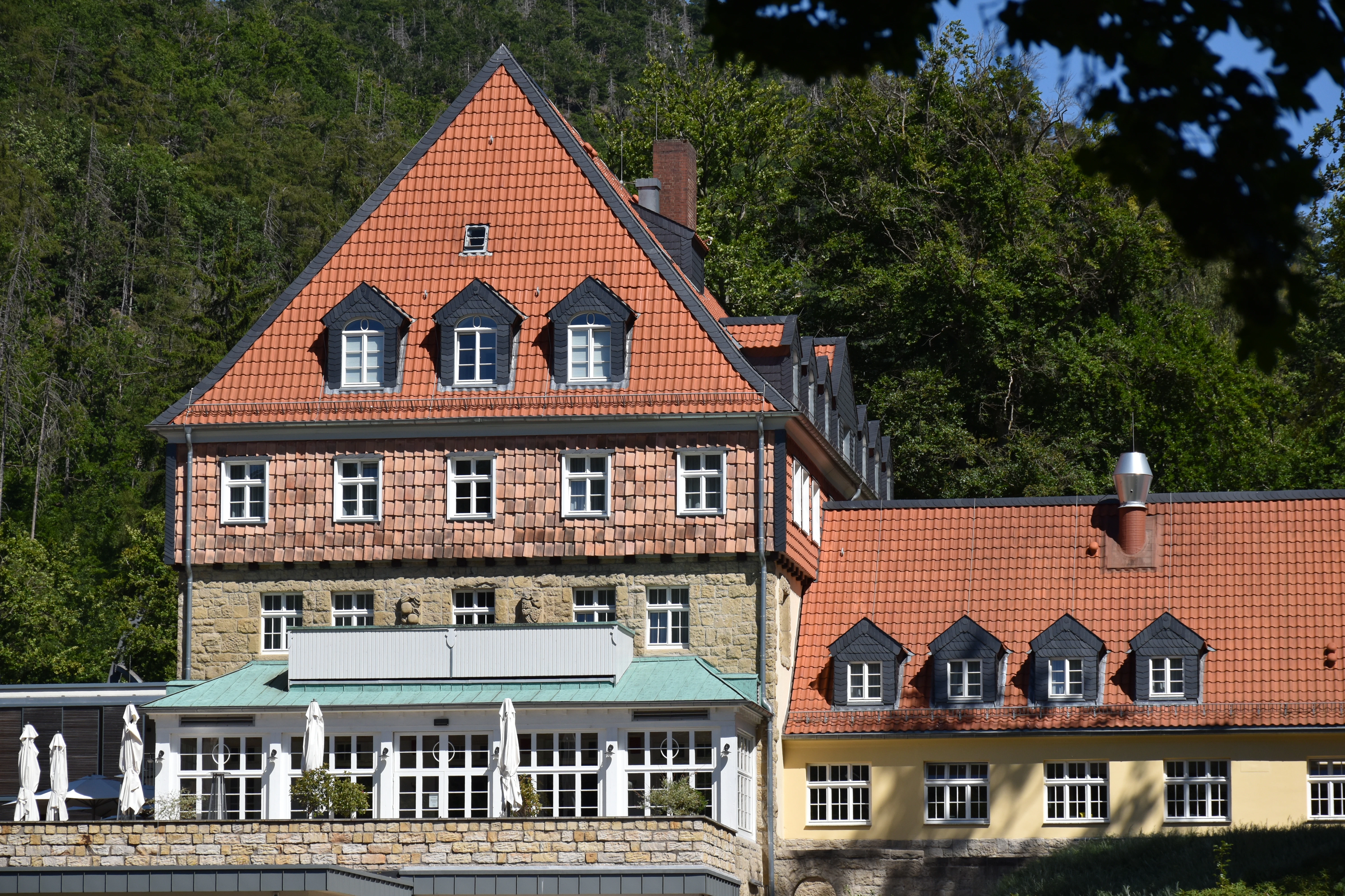 Historic building with red tiled roofs and dormer windows.