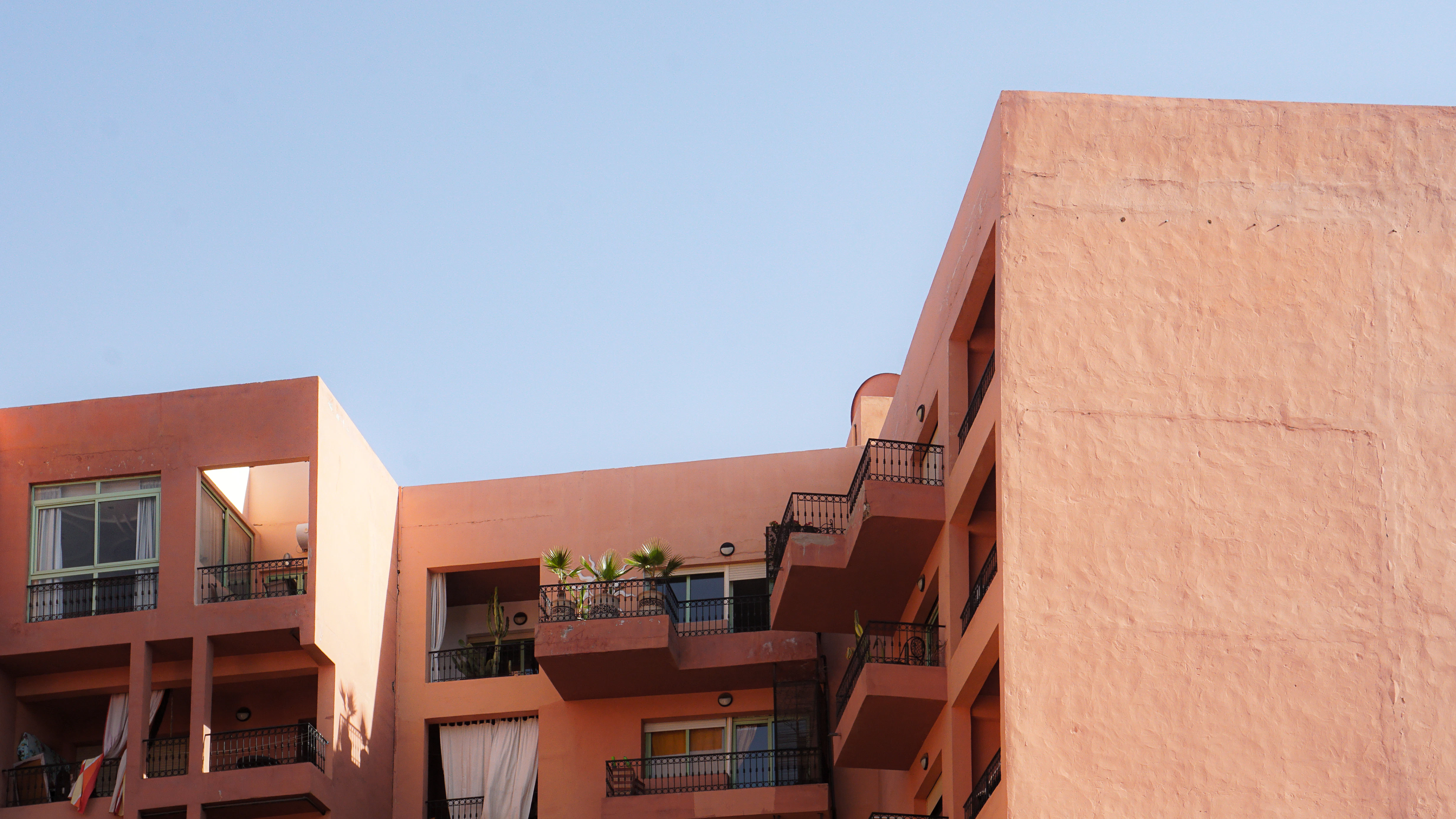 a pink building with balconies and a balcony