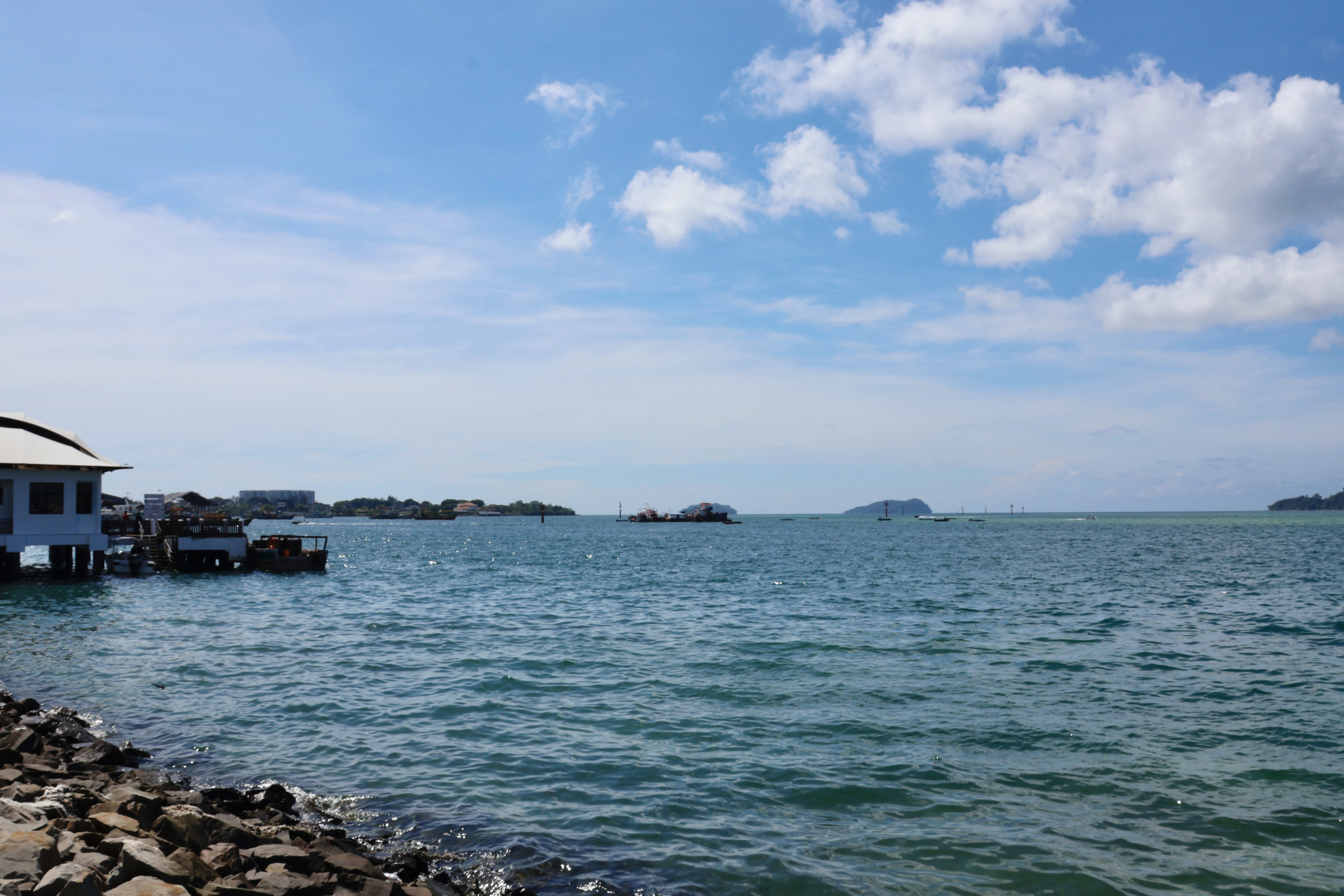Calm blue ocean under a partly cloudy sky.