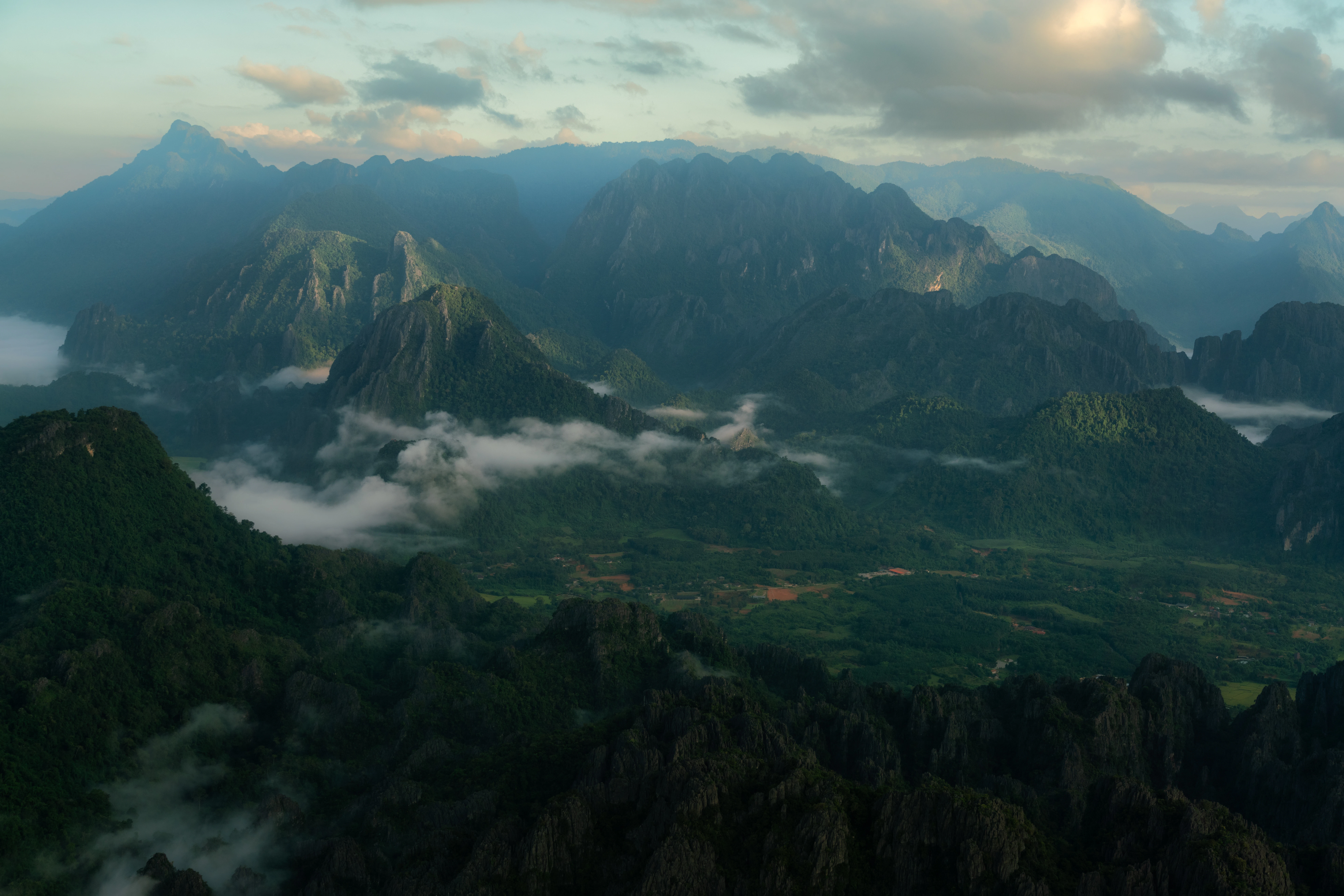 an aerial view of a mountain range with low lying clouds