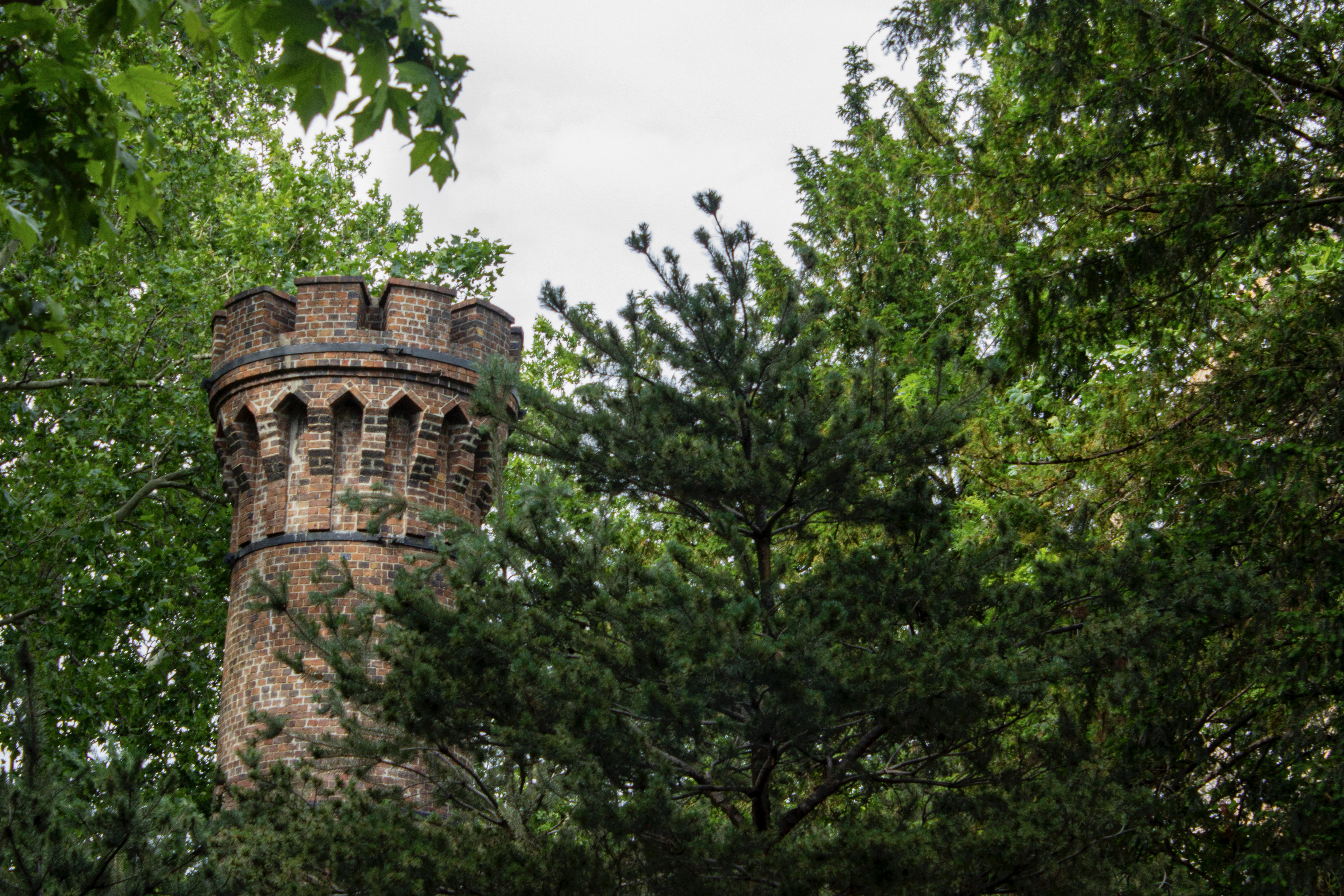 a brick tower behind trees