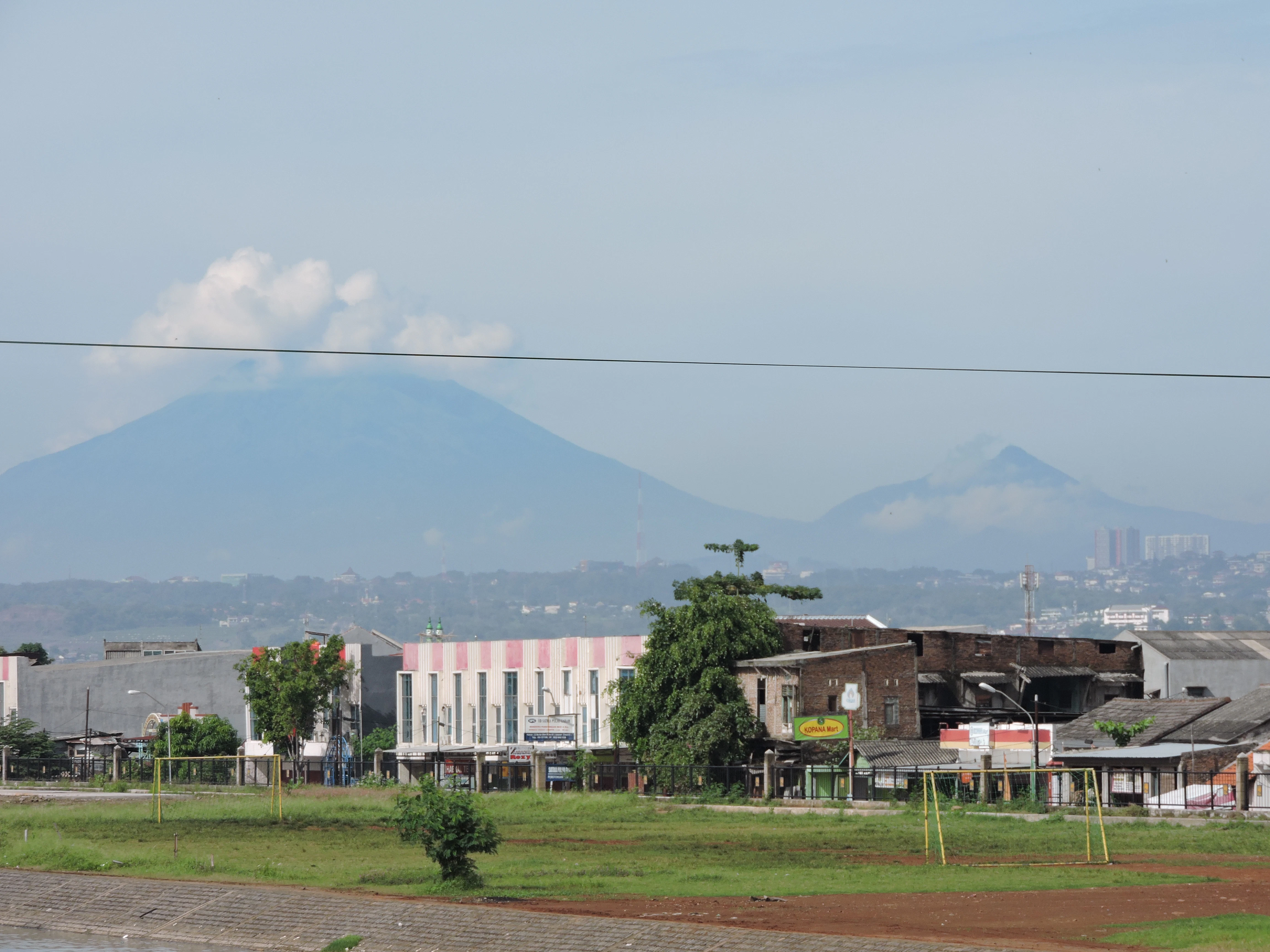 white and brown concrete building near green trees under white sky during daytime