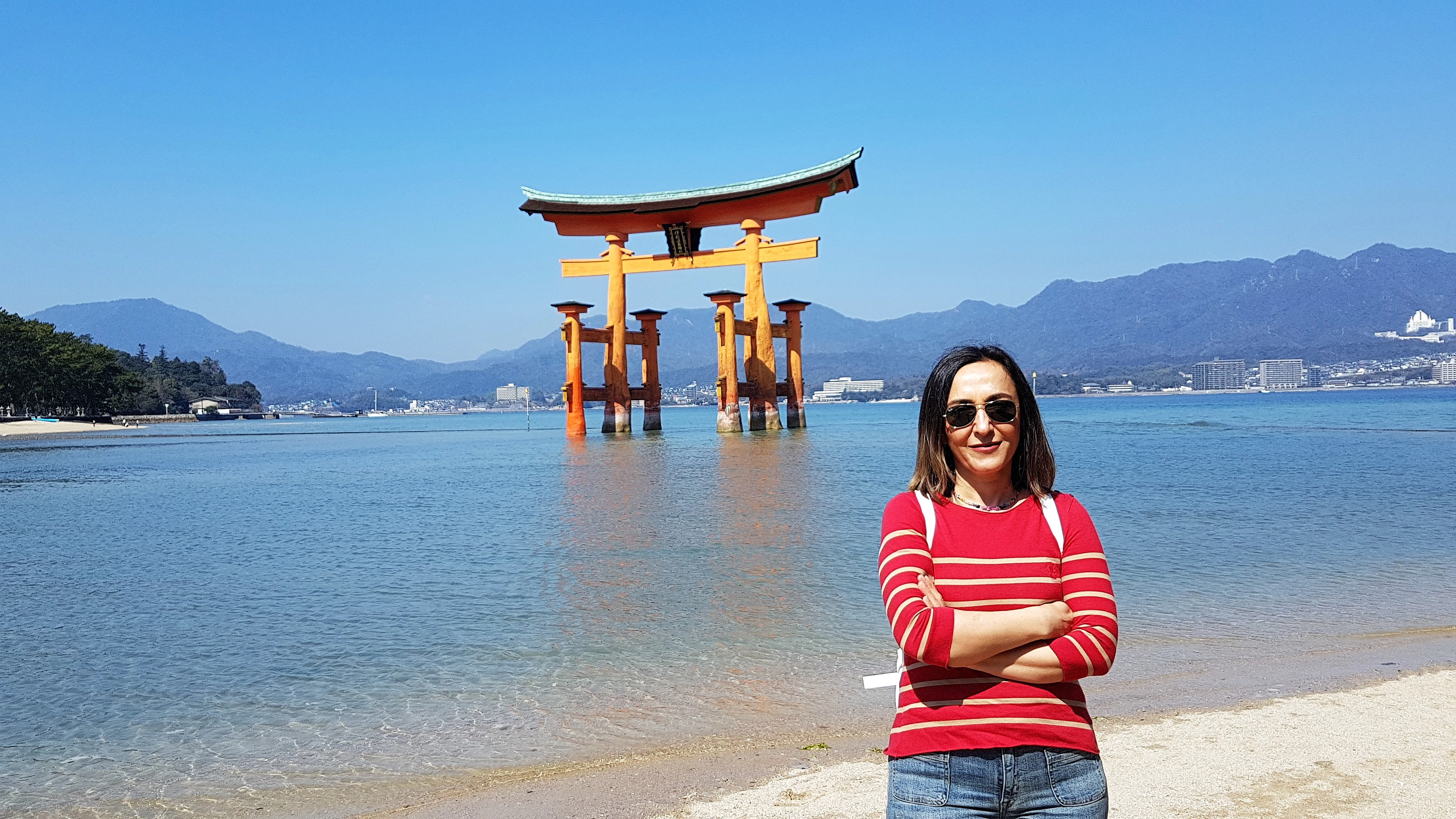 woman standing next to tori gate during daytime