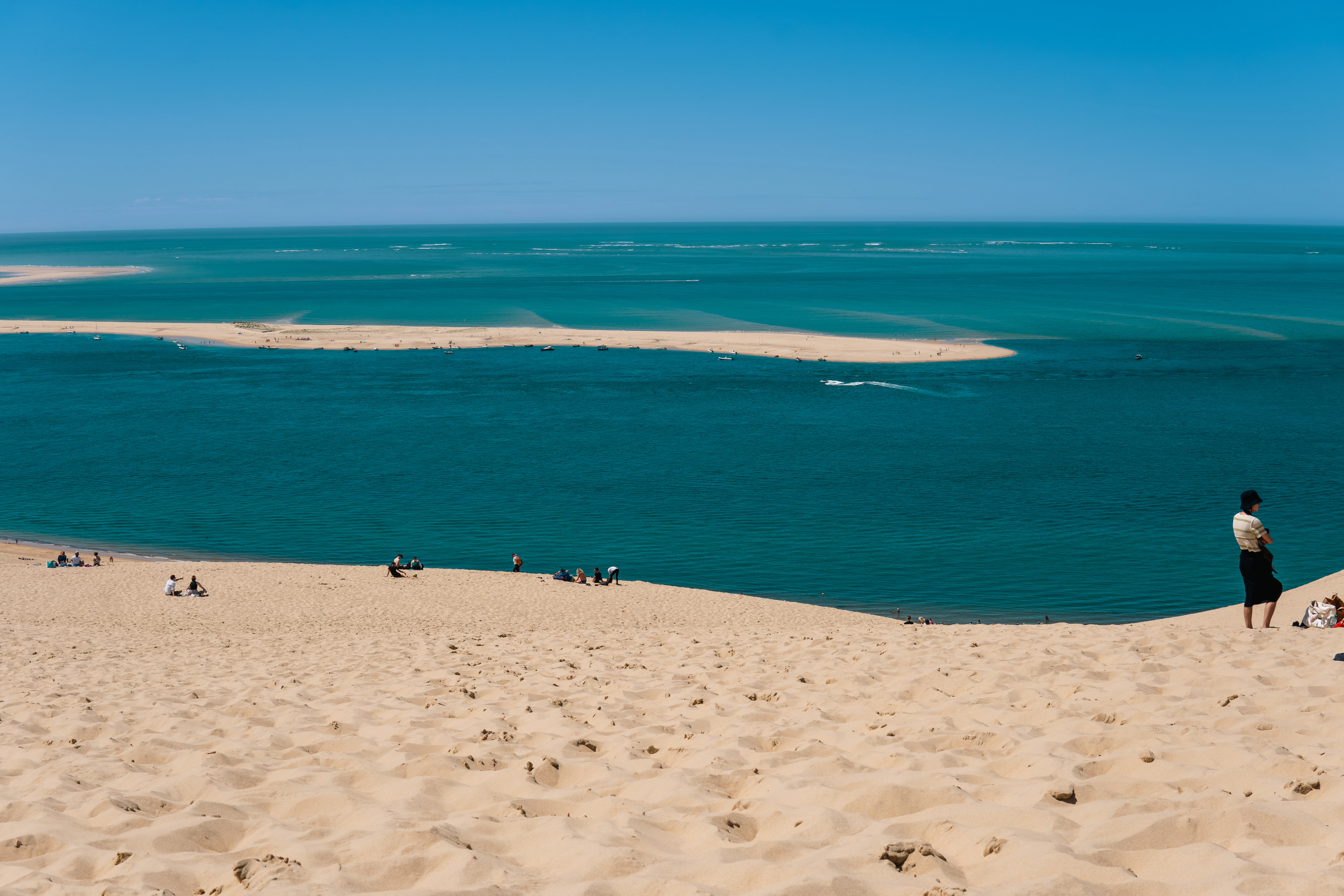 Sandy dunes overlook a beautiful turquoise ocean view.