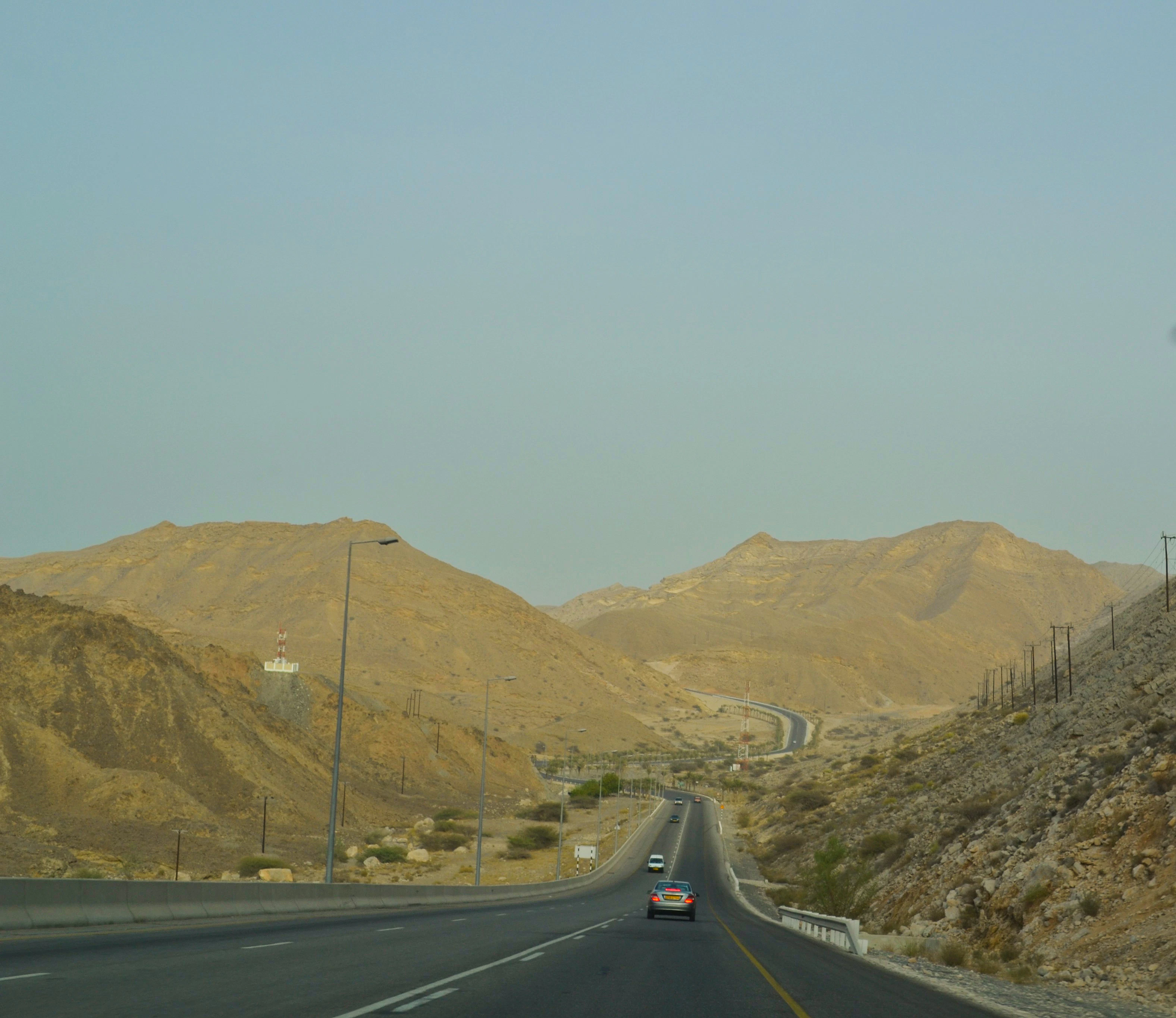 a car driving down a road with mountains in the background