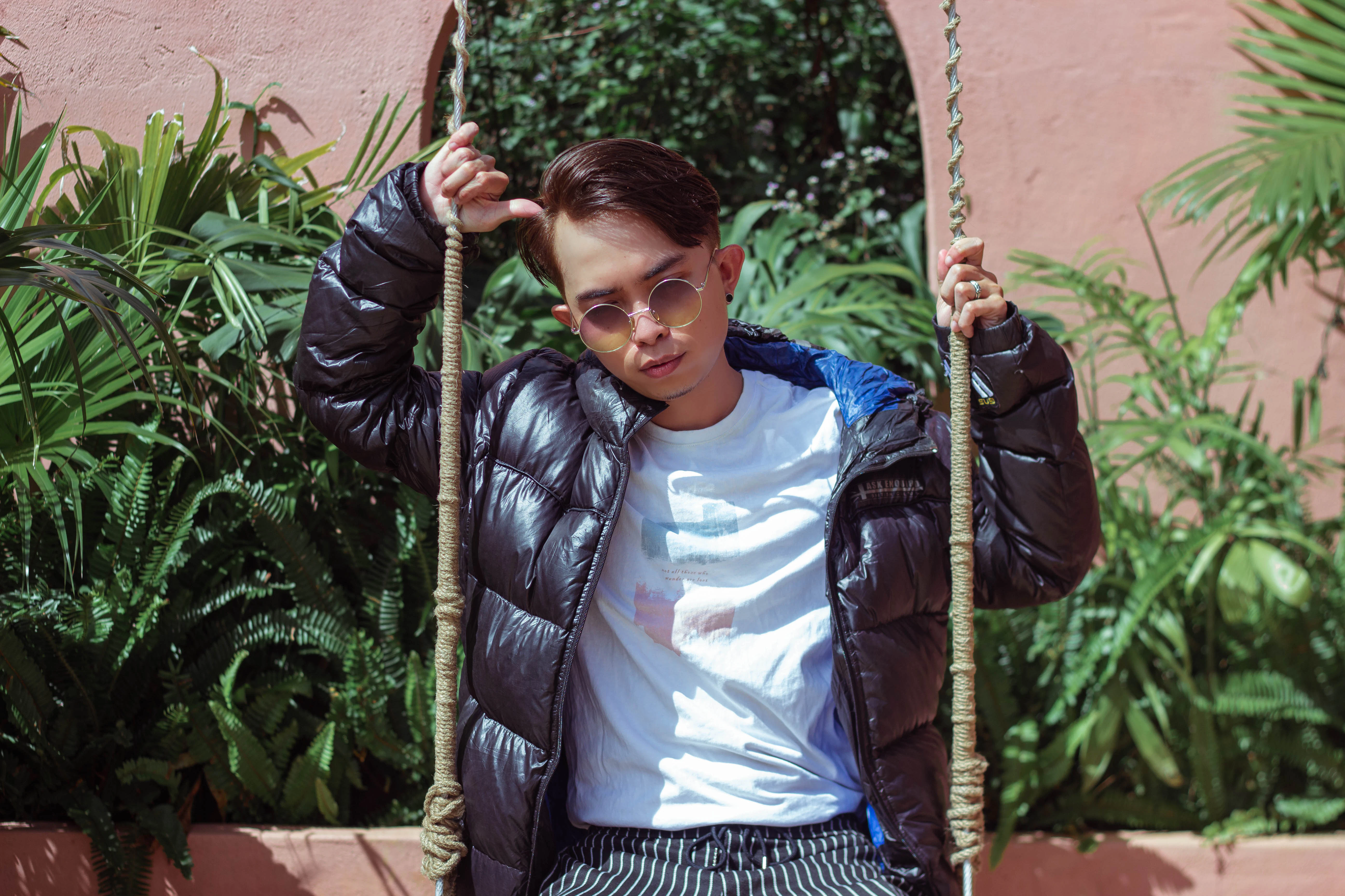 girl in blue and white striped shirt and black and white striped pants sitting on swing