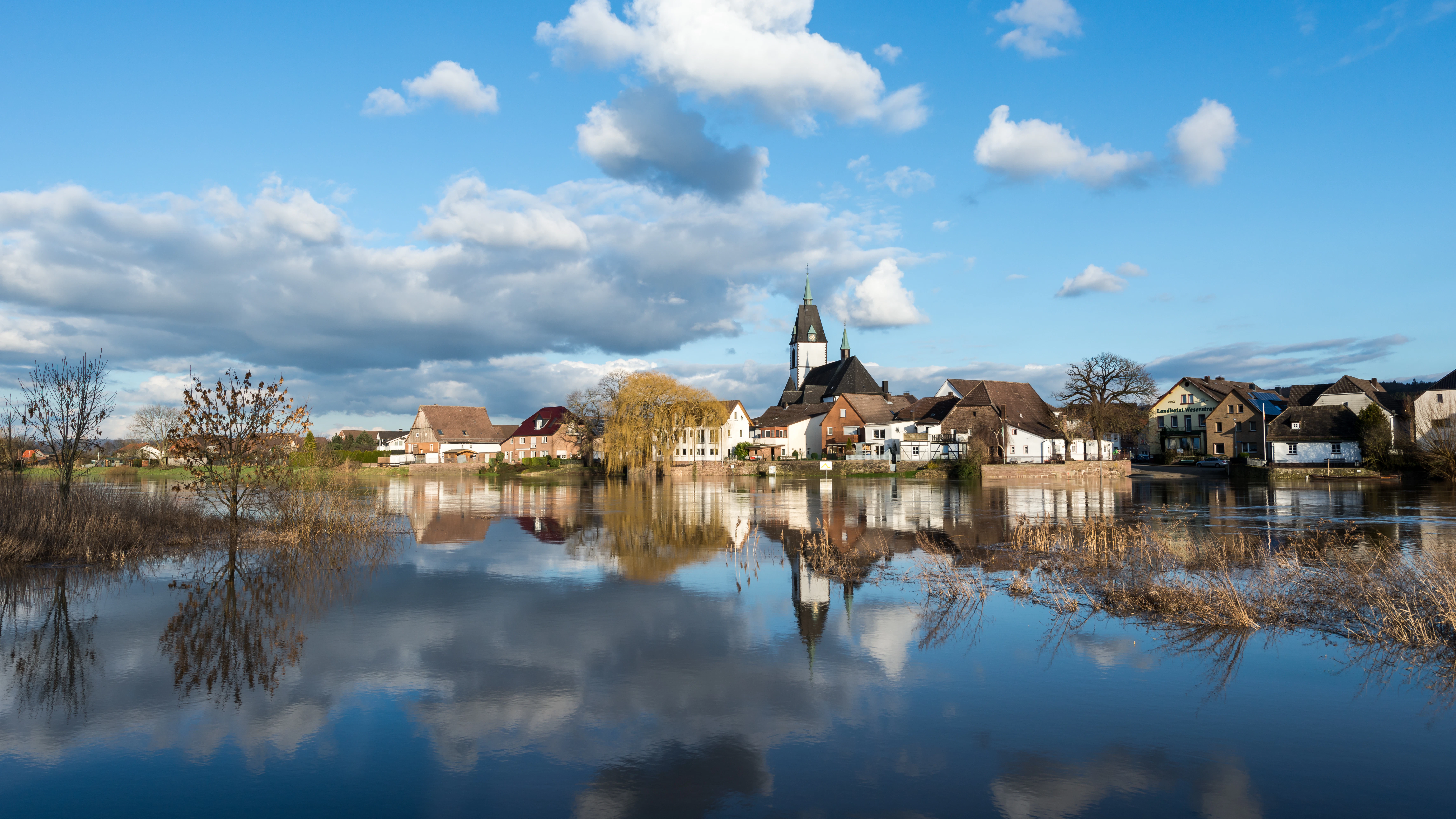 A body of water with houses in the background