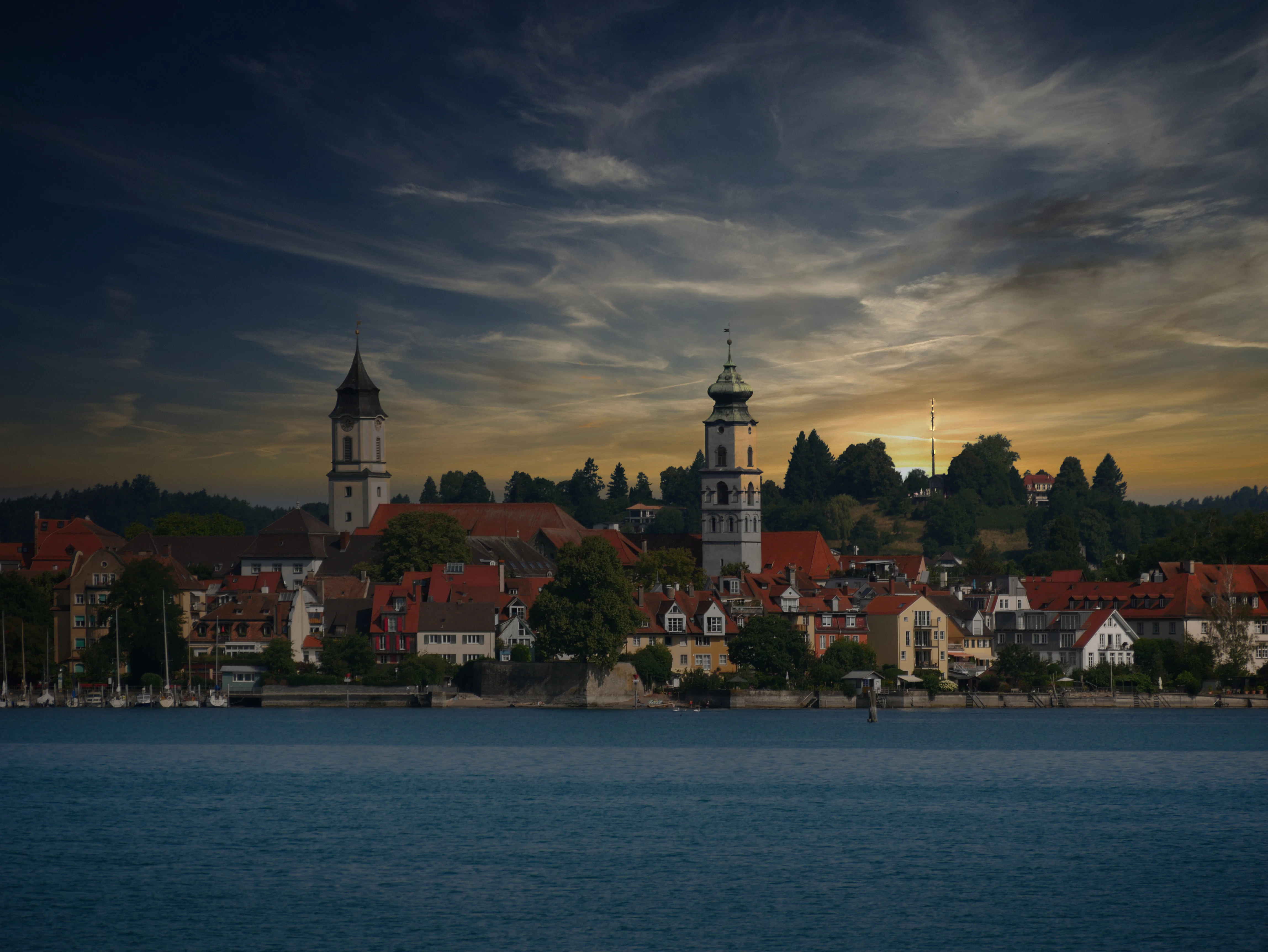 Historic european town skyline at dusk over water.