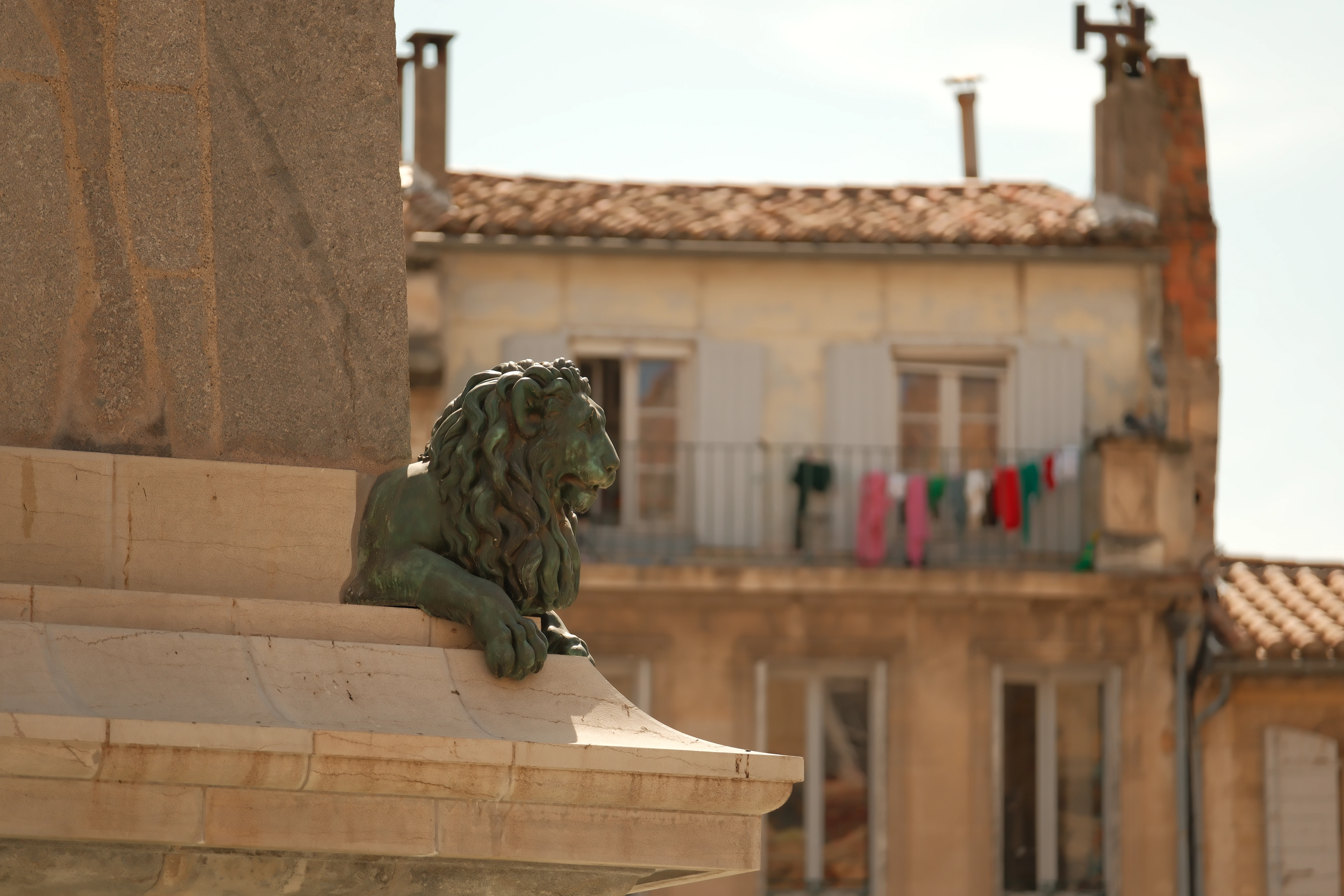 Bronze lion statue on a pedestal with building background