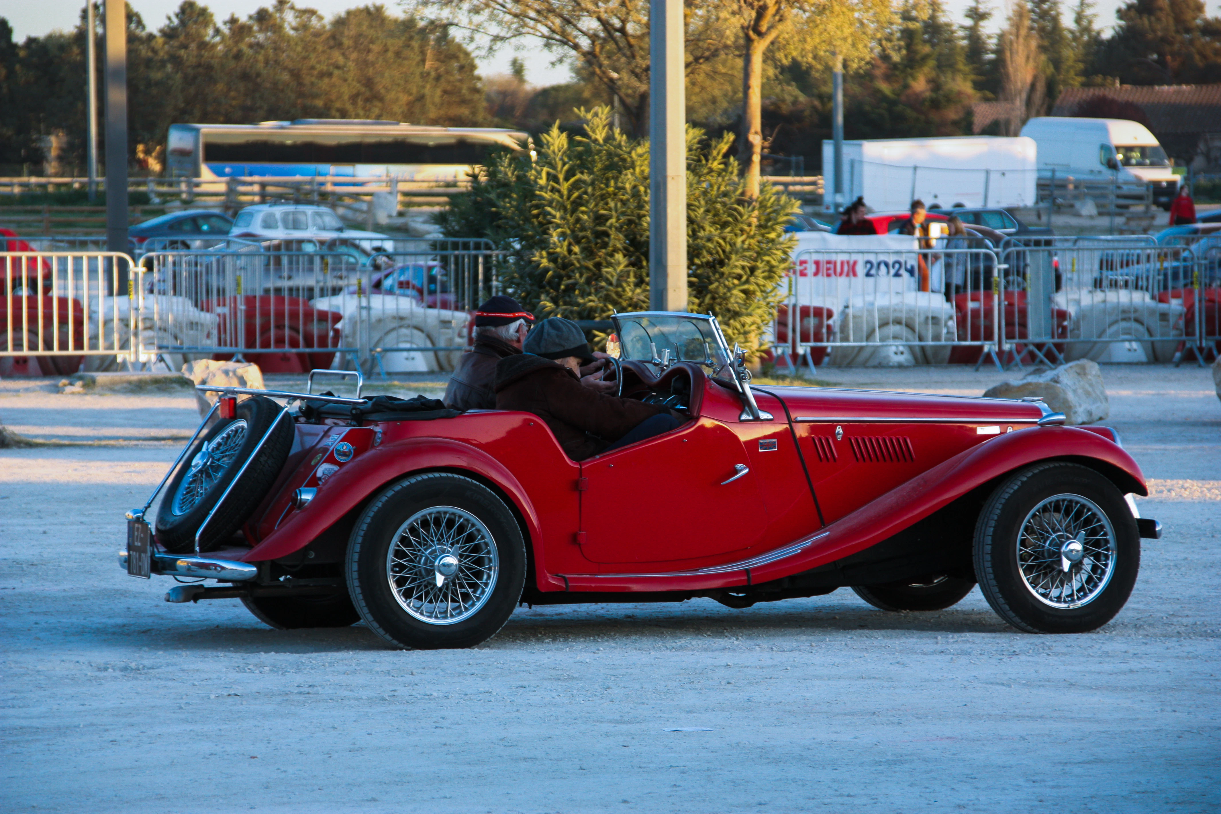 A red vintage convertible car parked outdoors.