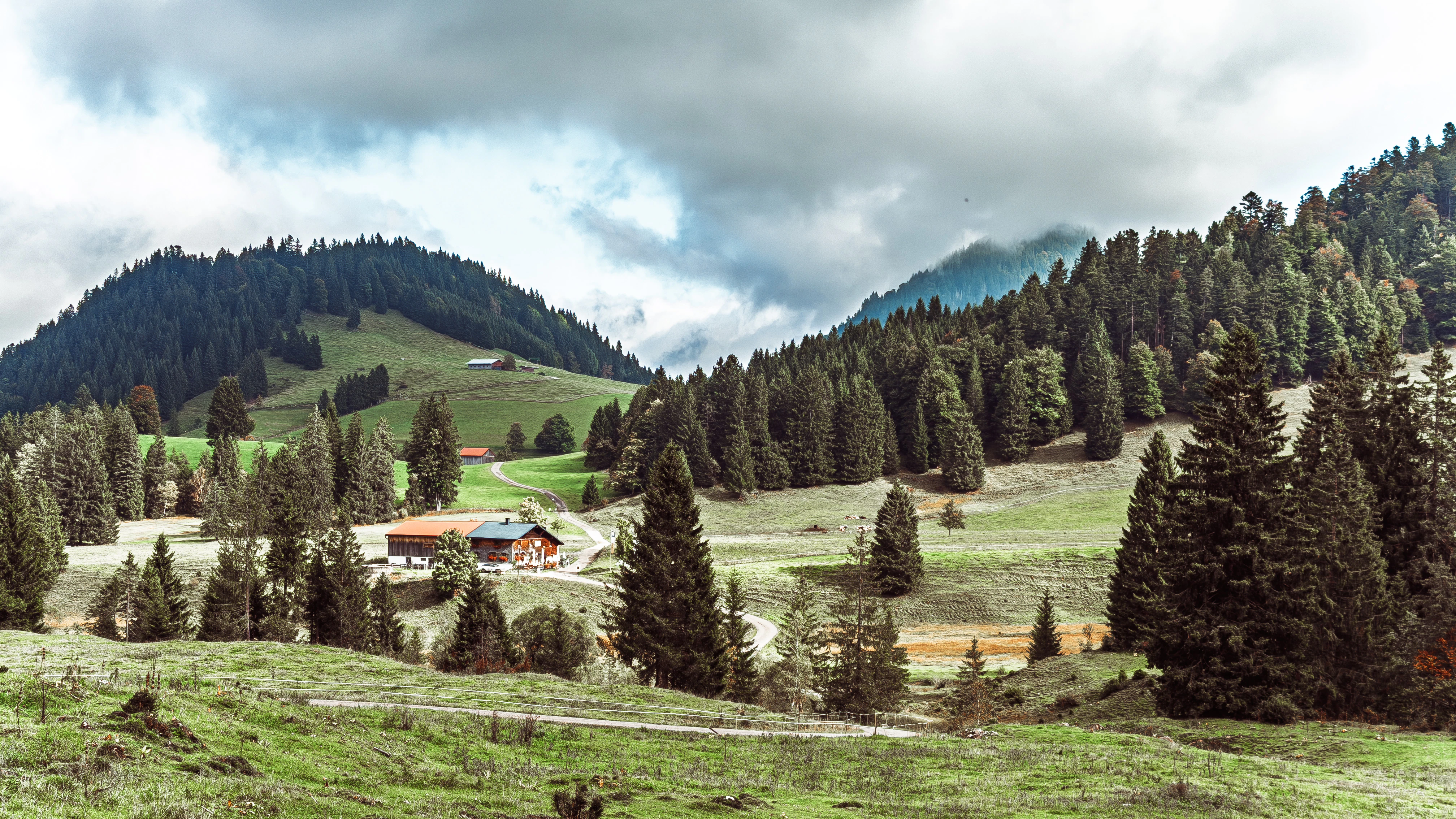 Green rolling hills with scattered trees and buildings.