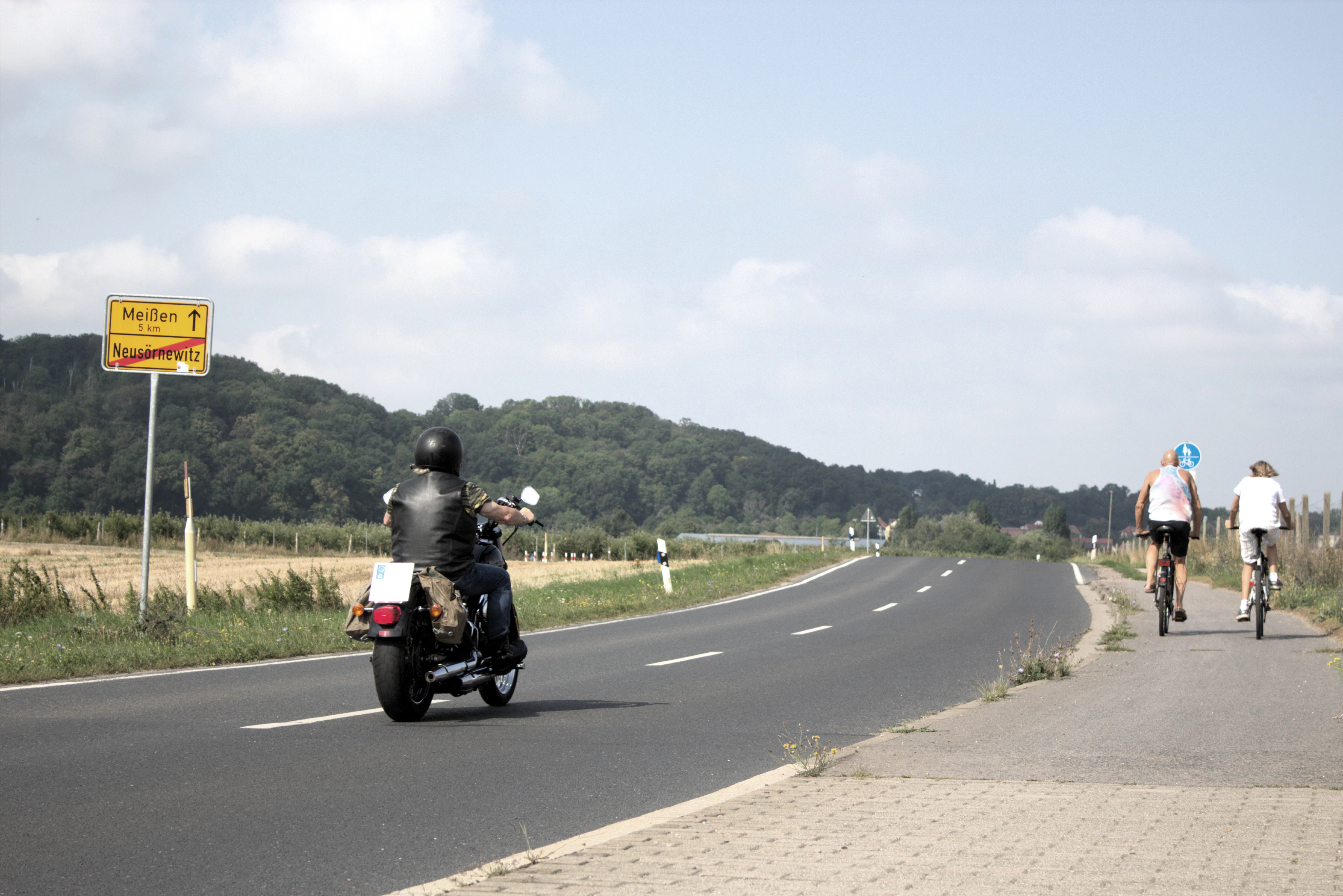 a group of people riding motorcycles down a road