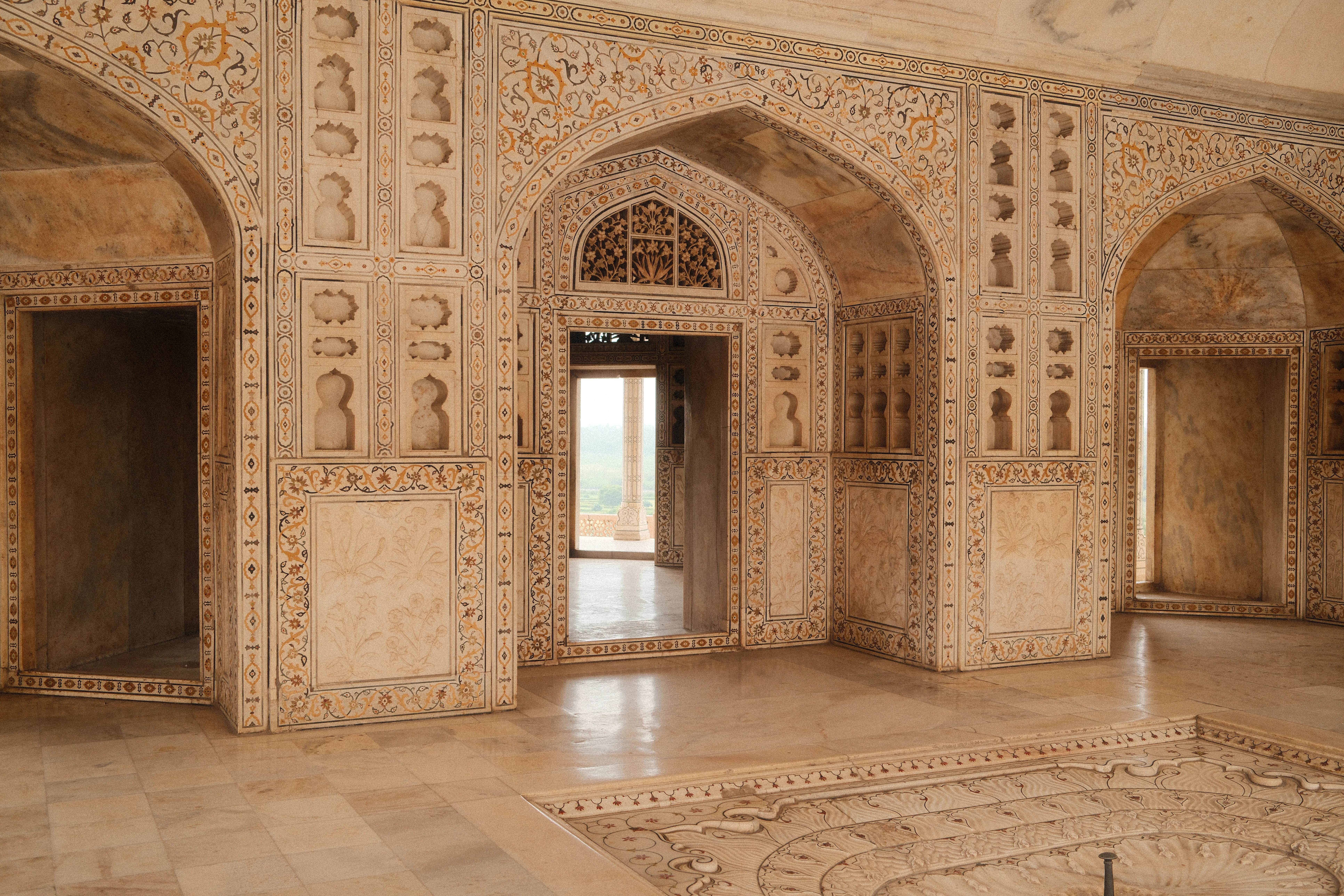 Intricate white marble architecture with arched doorways.