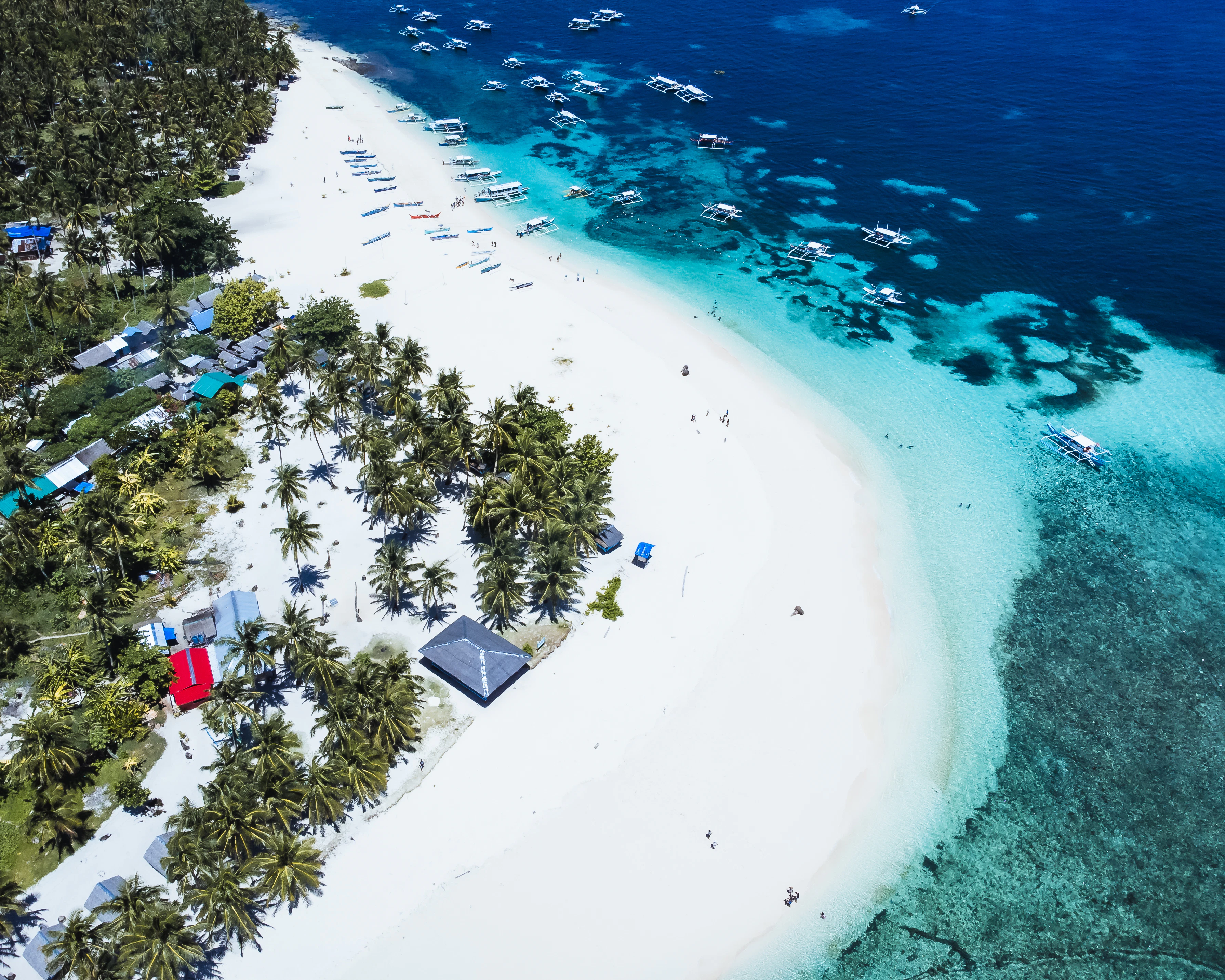 An aerial view of a tropical island with a white sand beach