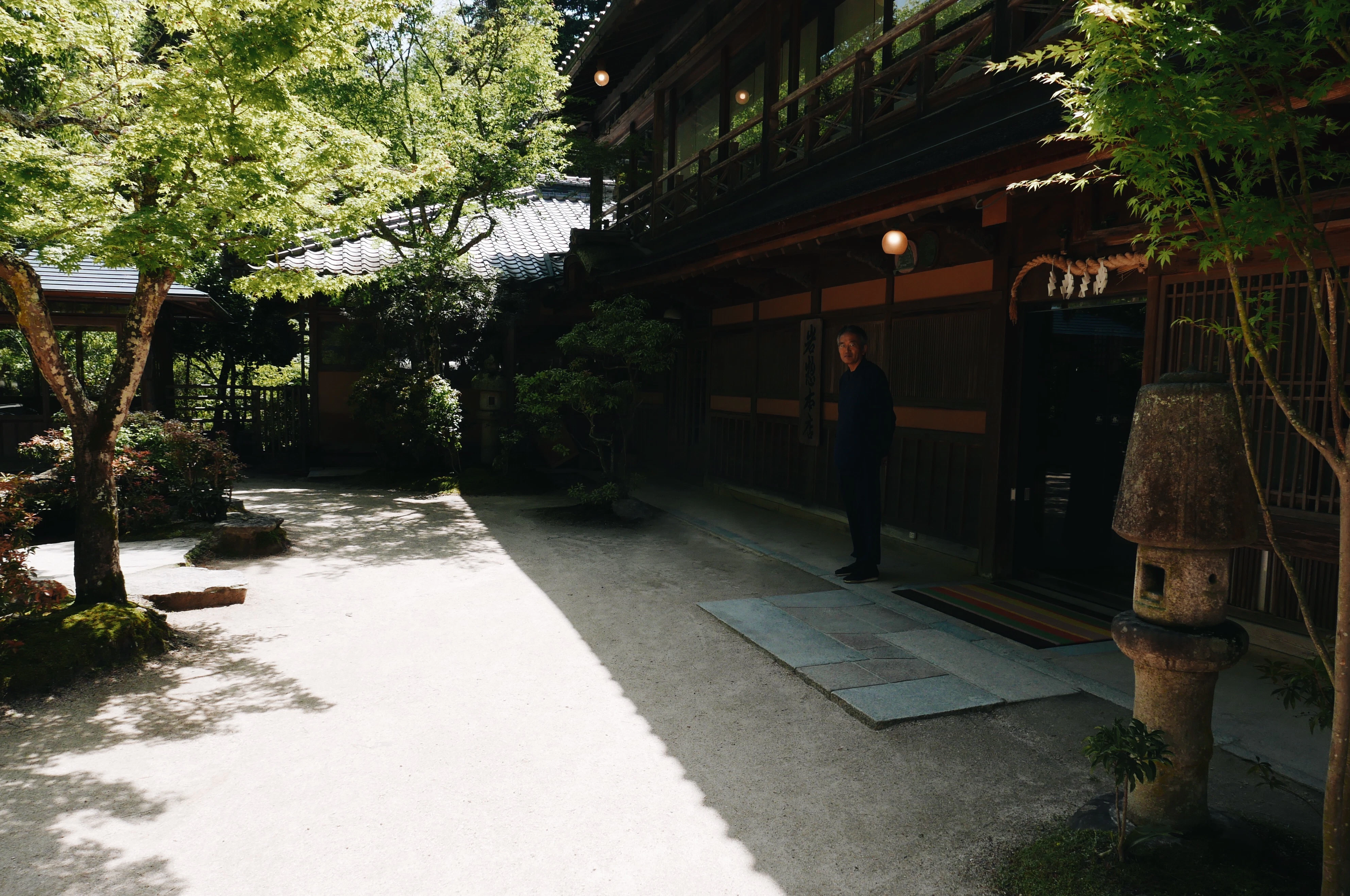 man standing outside brown wooden building at daytime