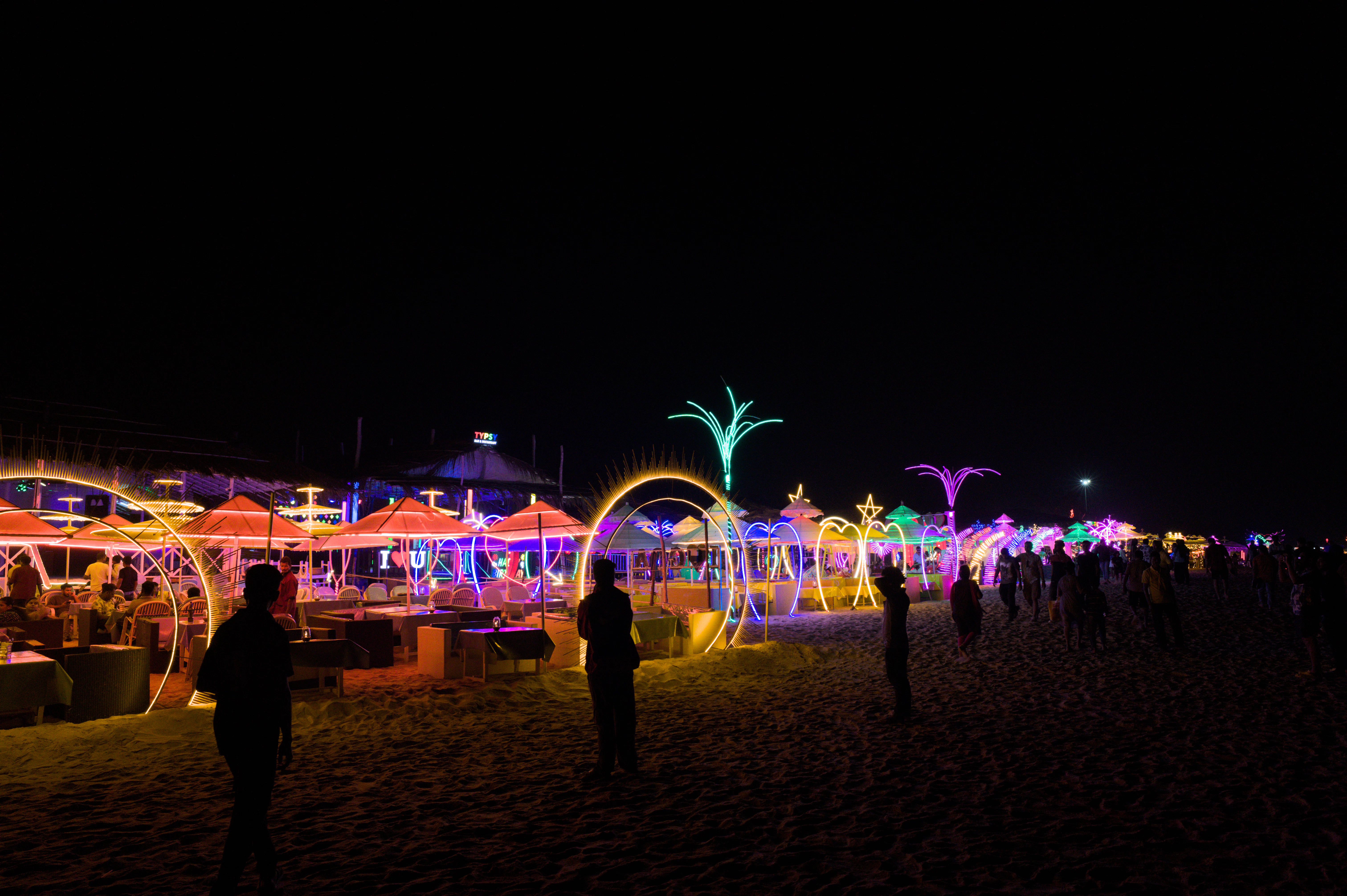 A group of people standing on top of a sandy beach