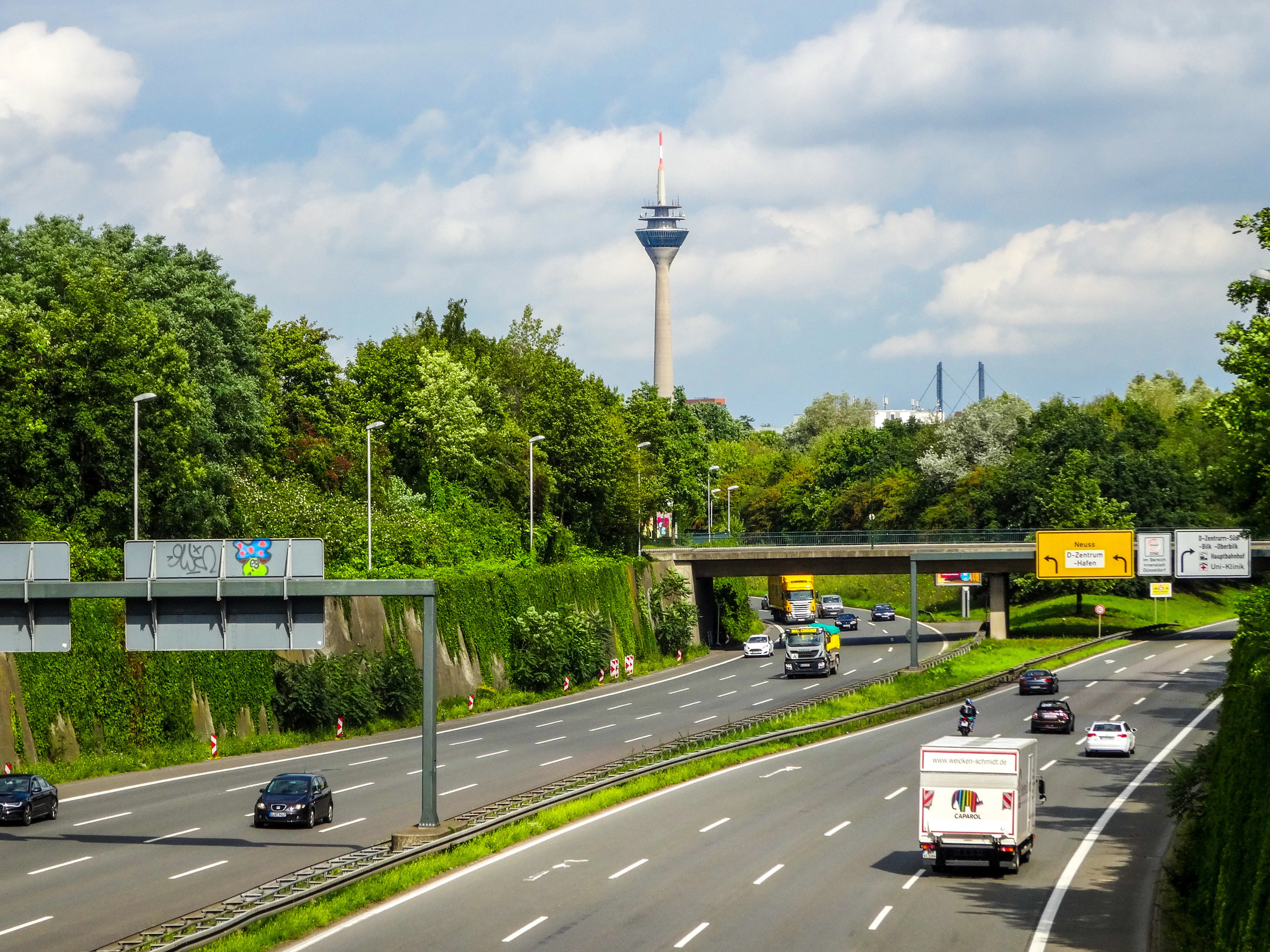 Cars driving on a highway with a tower in background