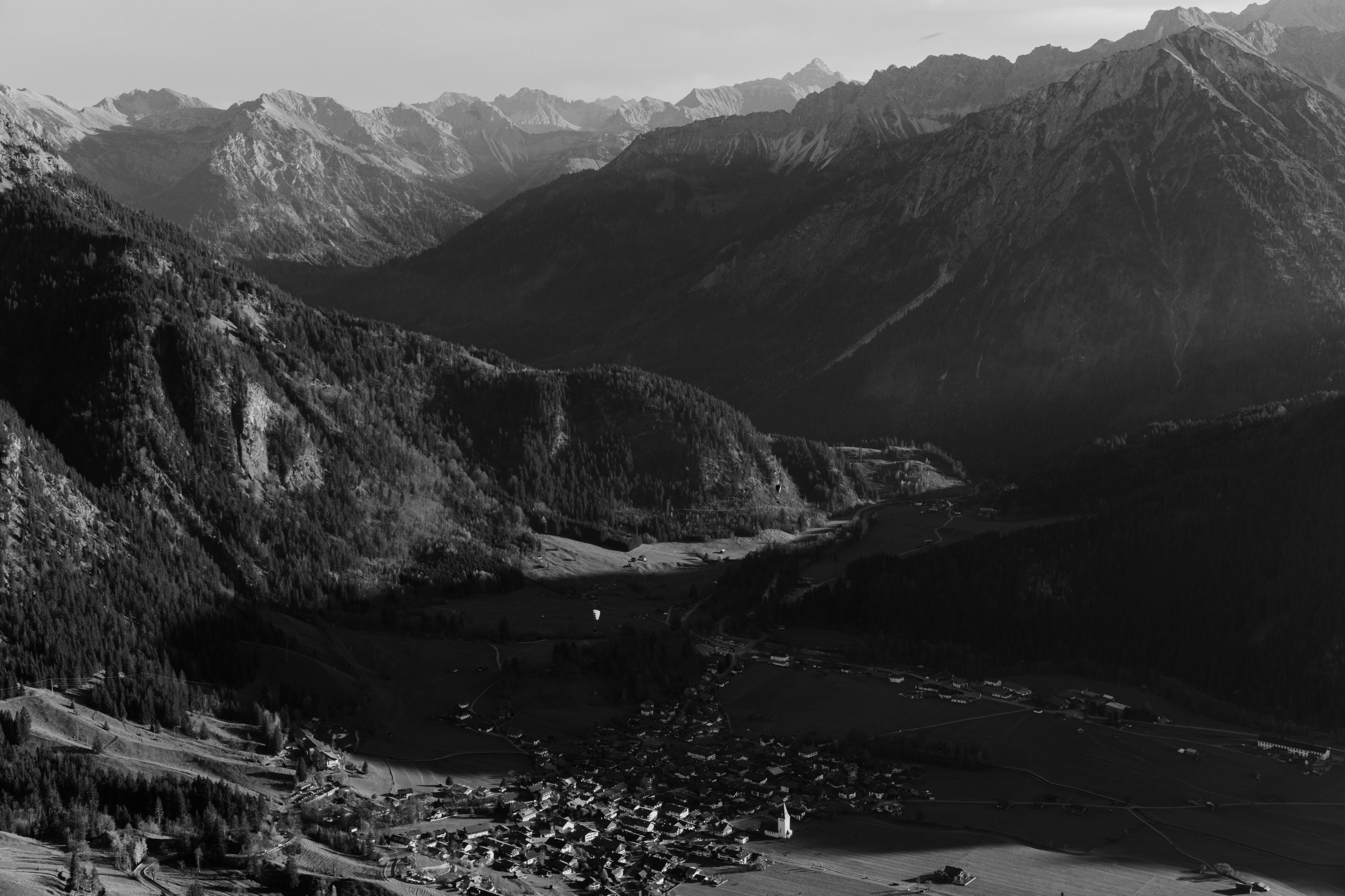 A village nestled in a valley surrounded by mountains.