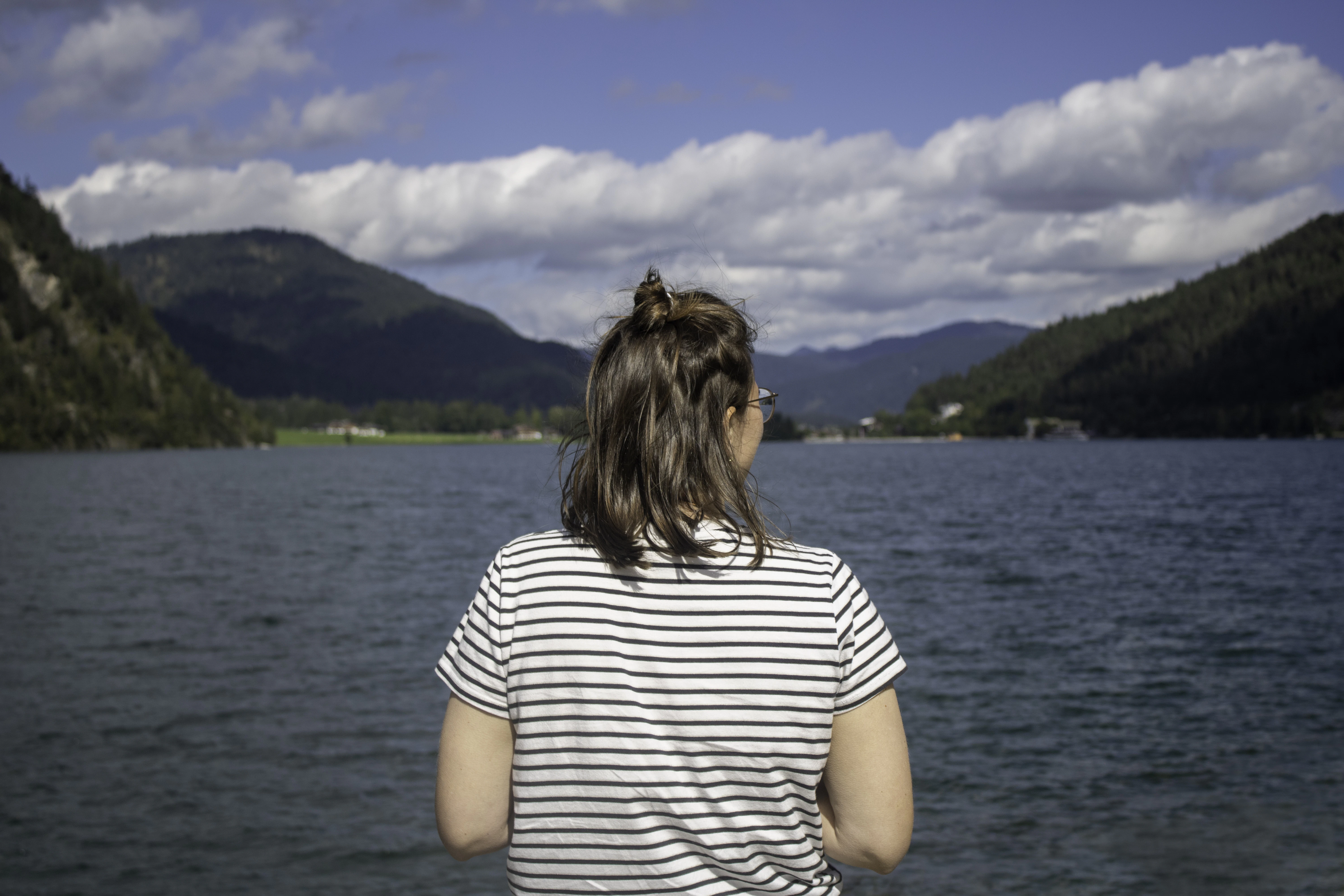 a woman standing in front of a body of water