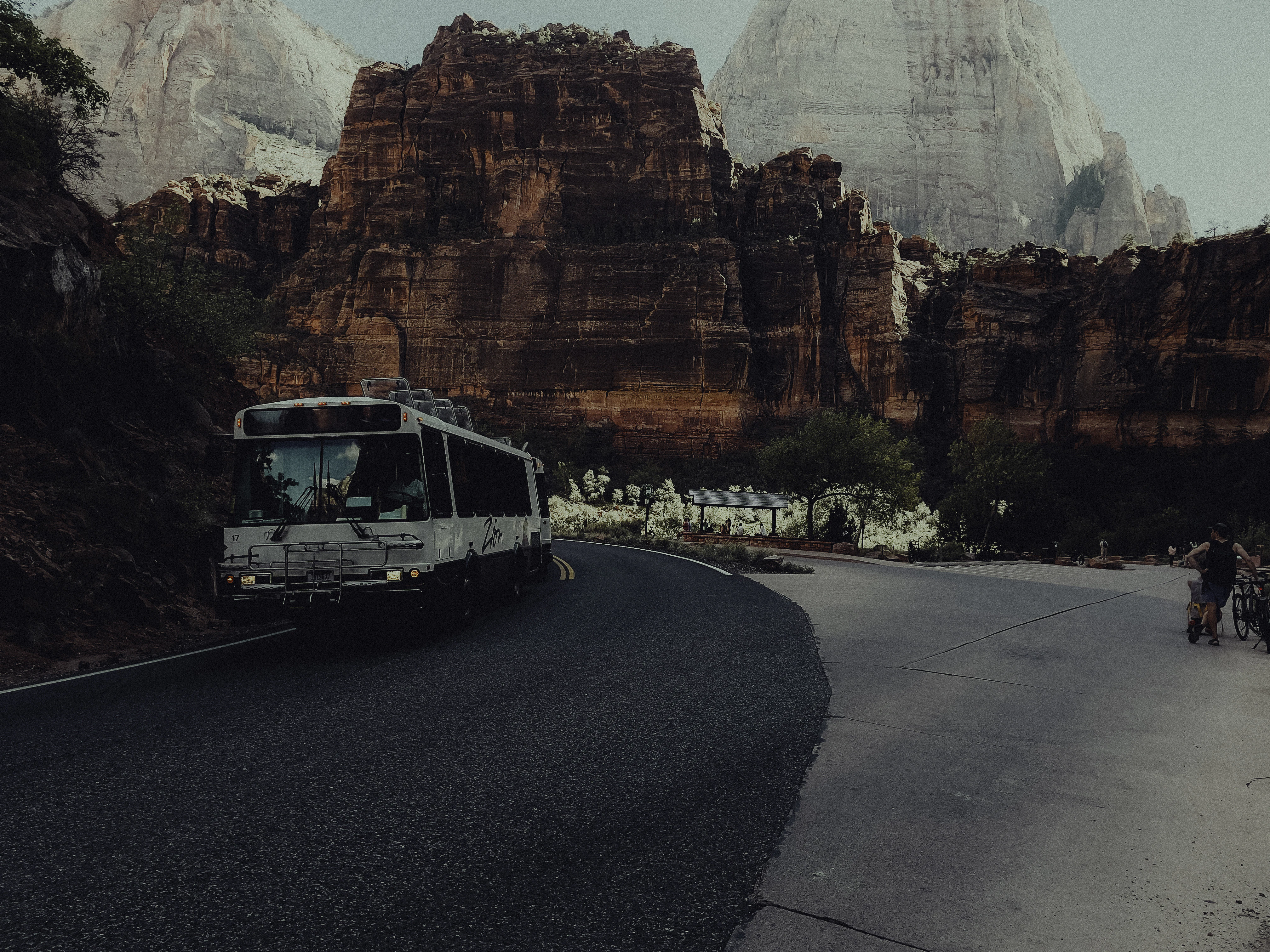 A bus driving down a road next to mountains