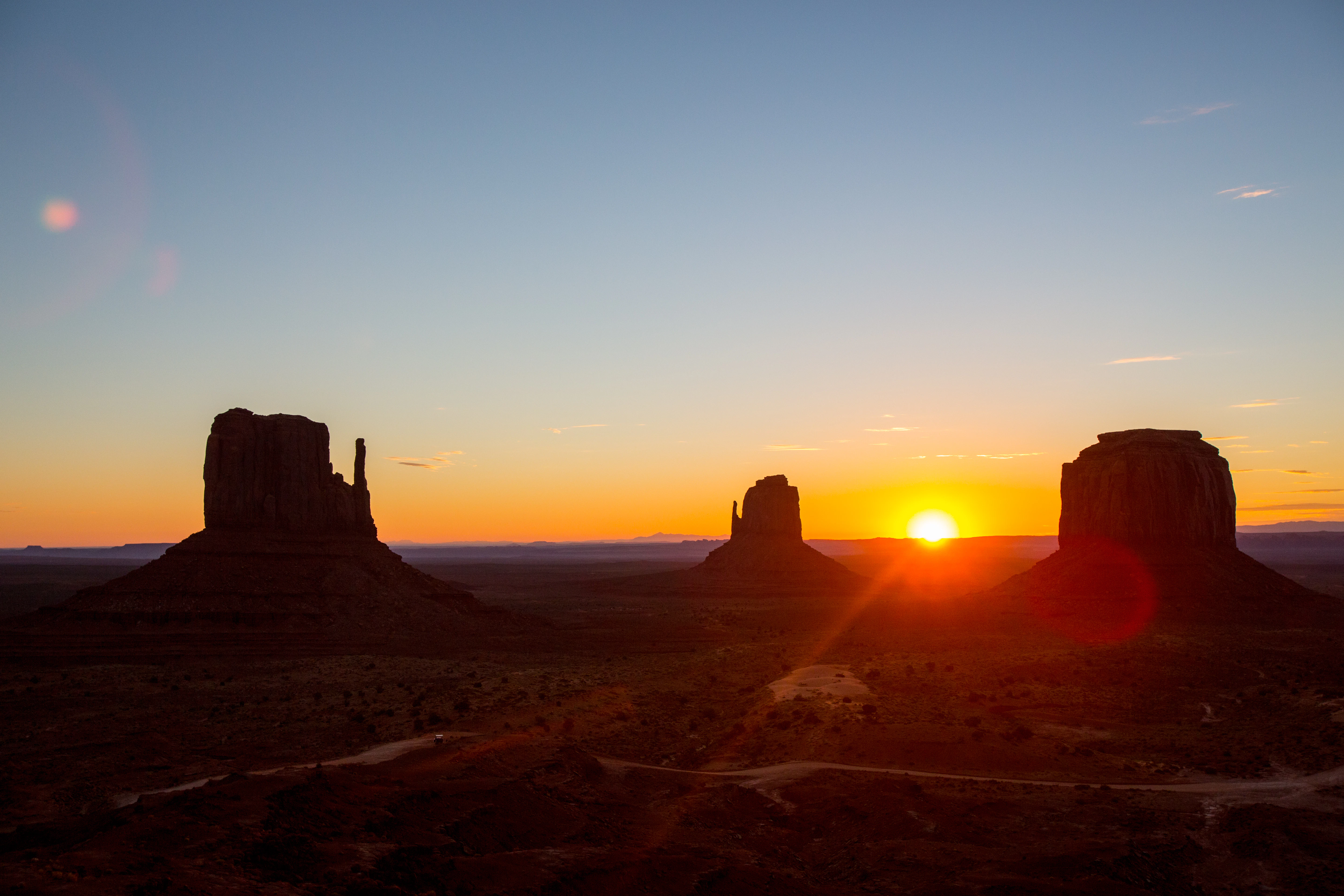 The sun is setting over a desert landscape