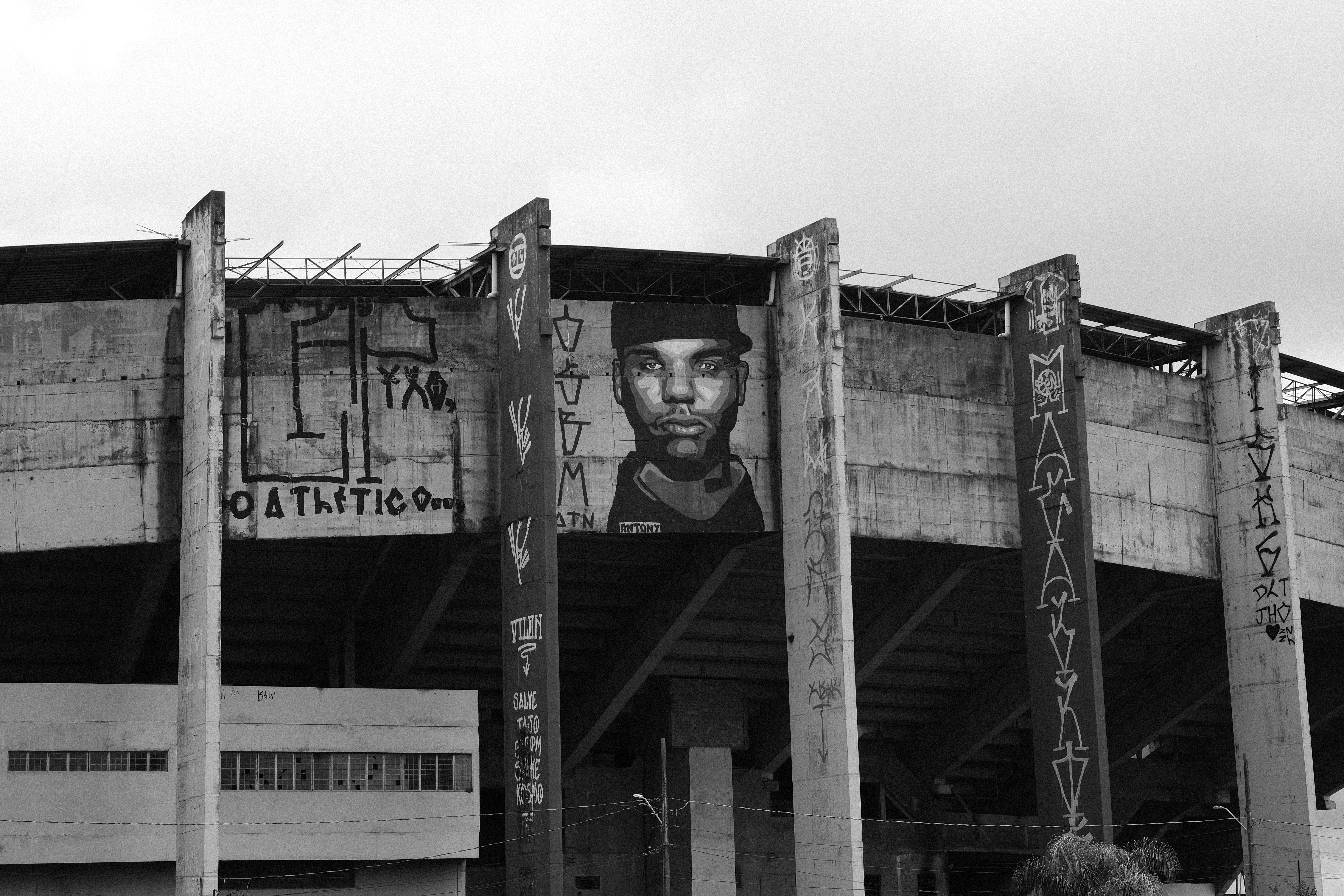 Graffiti portrait on stadium exterior wall with barbed wire