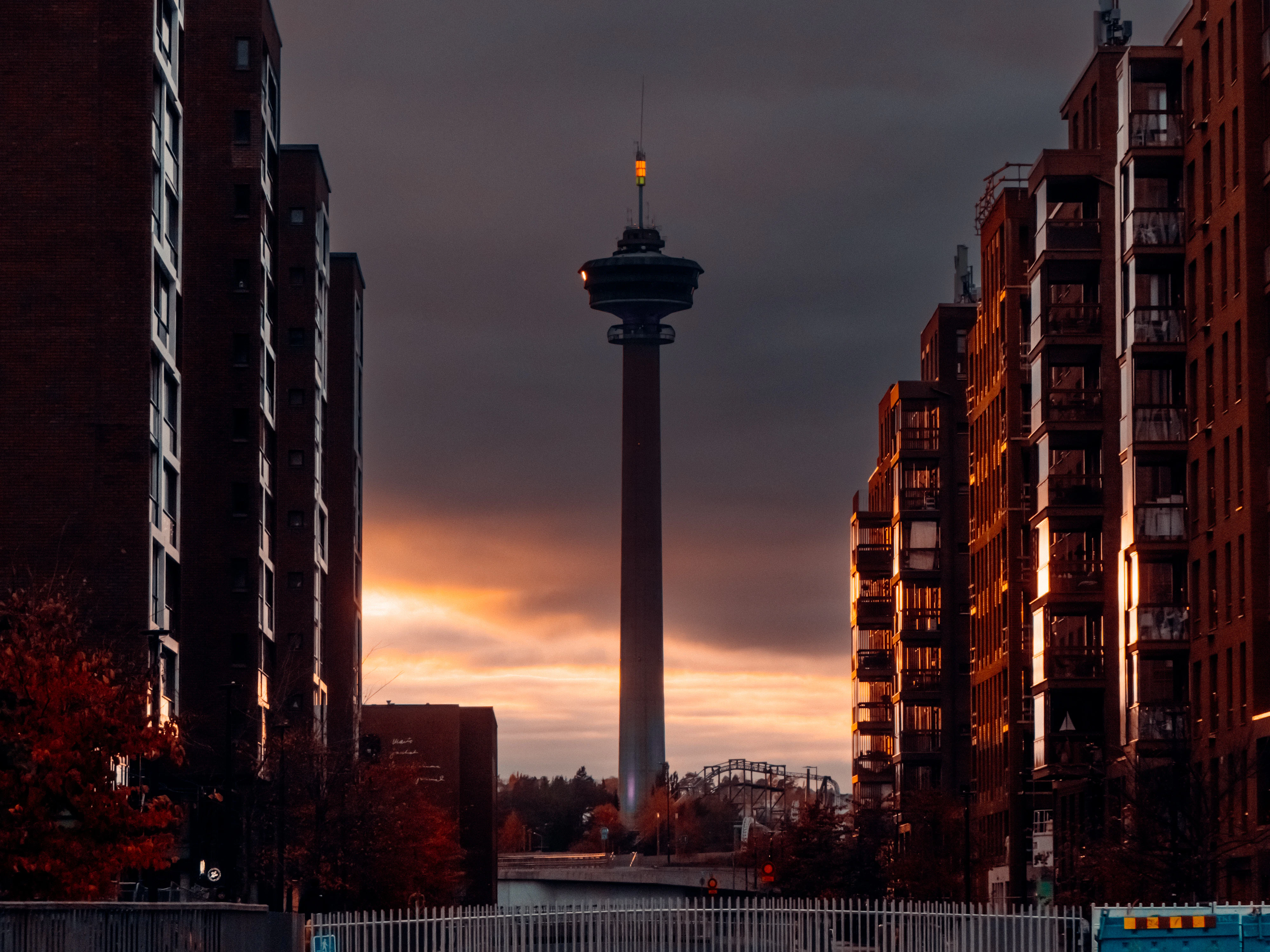 Tall observation tower between apartment buildings at sunset