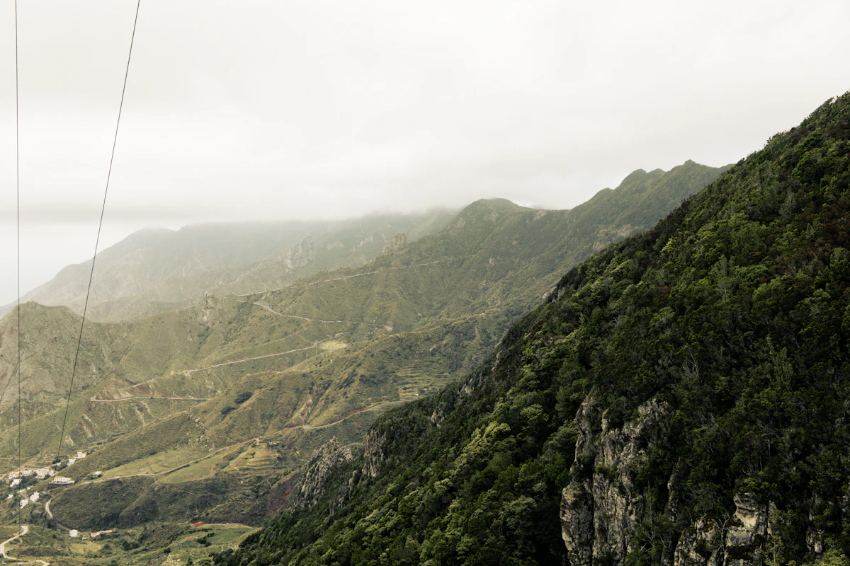 Green forested mountains under a hazy sky