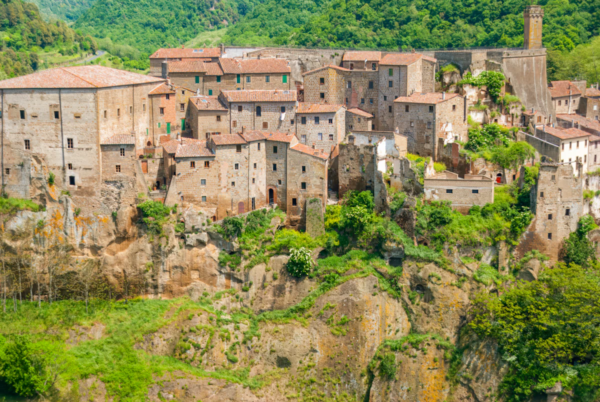 A village on a cliff with a mountain in the background