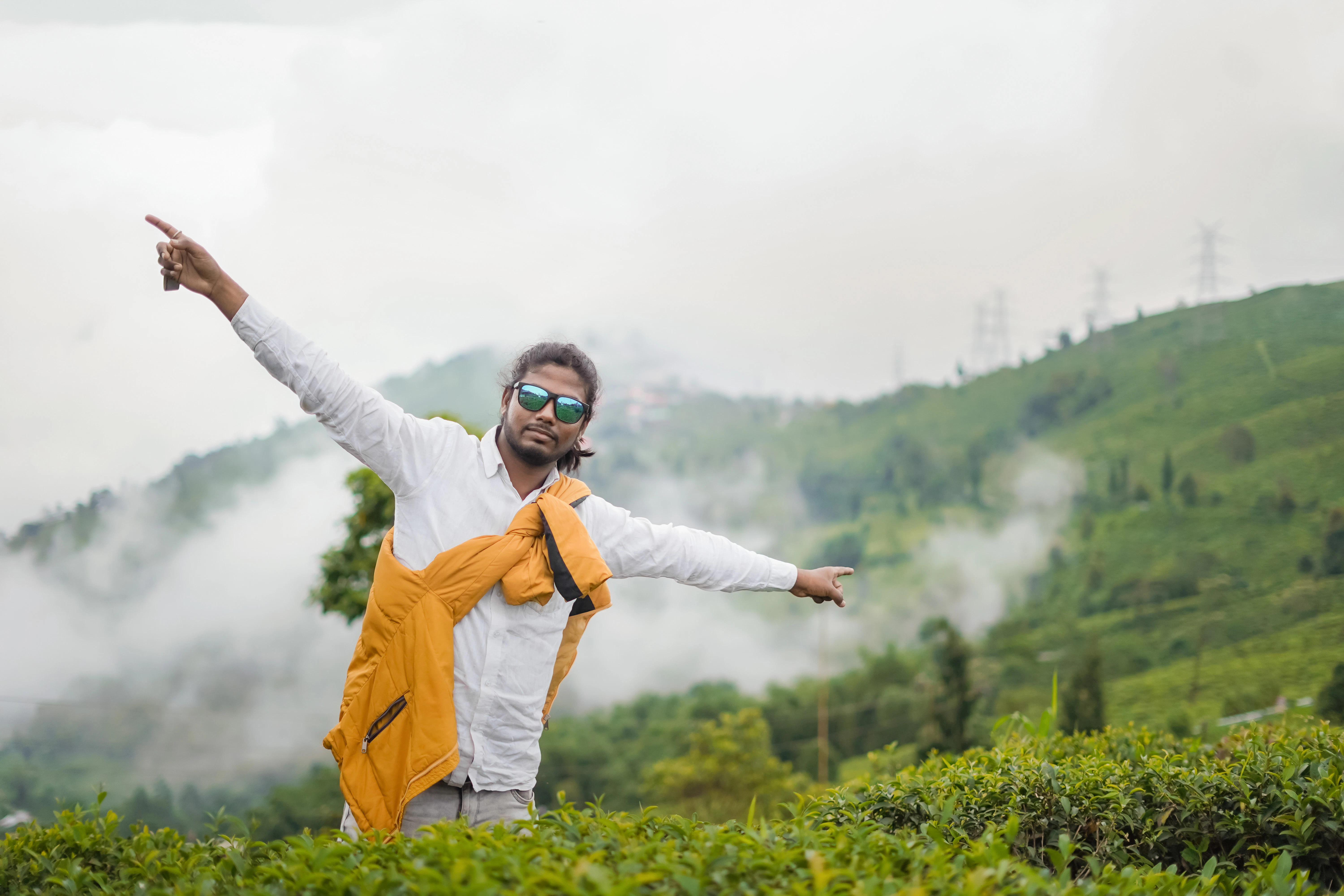 Man posing in a misty green tea plantation