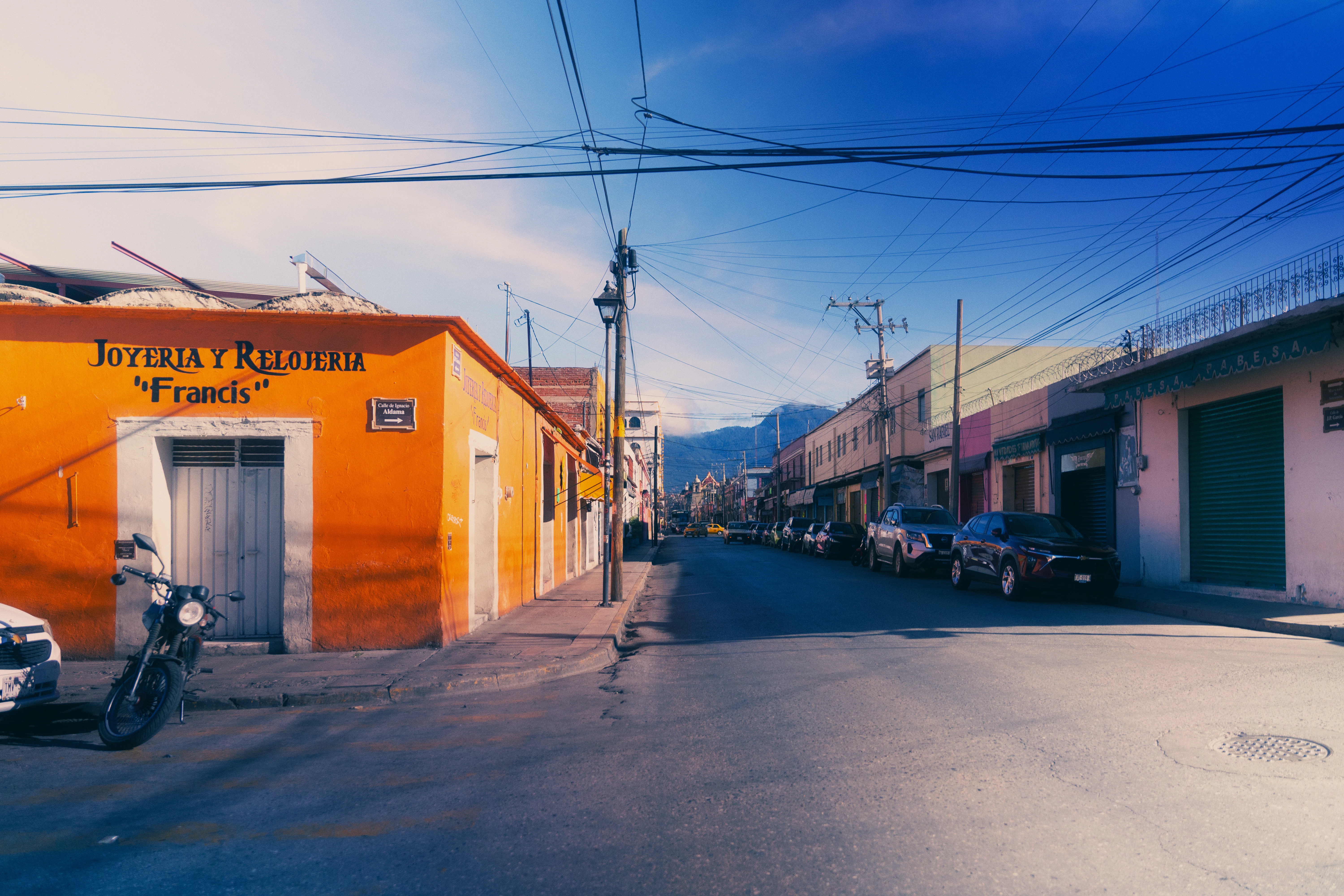 Orange building on a street with parked cars.