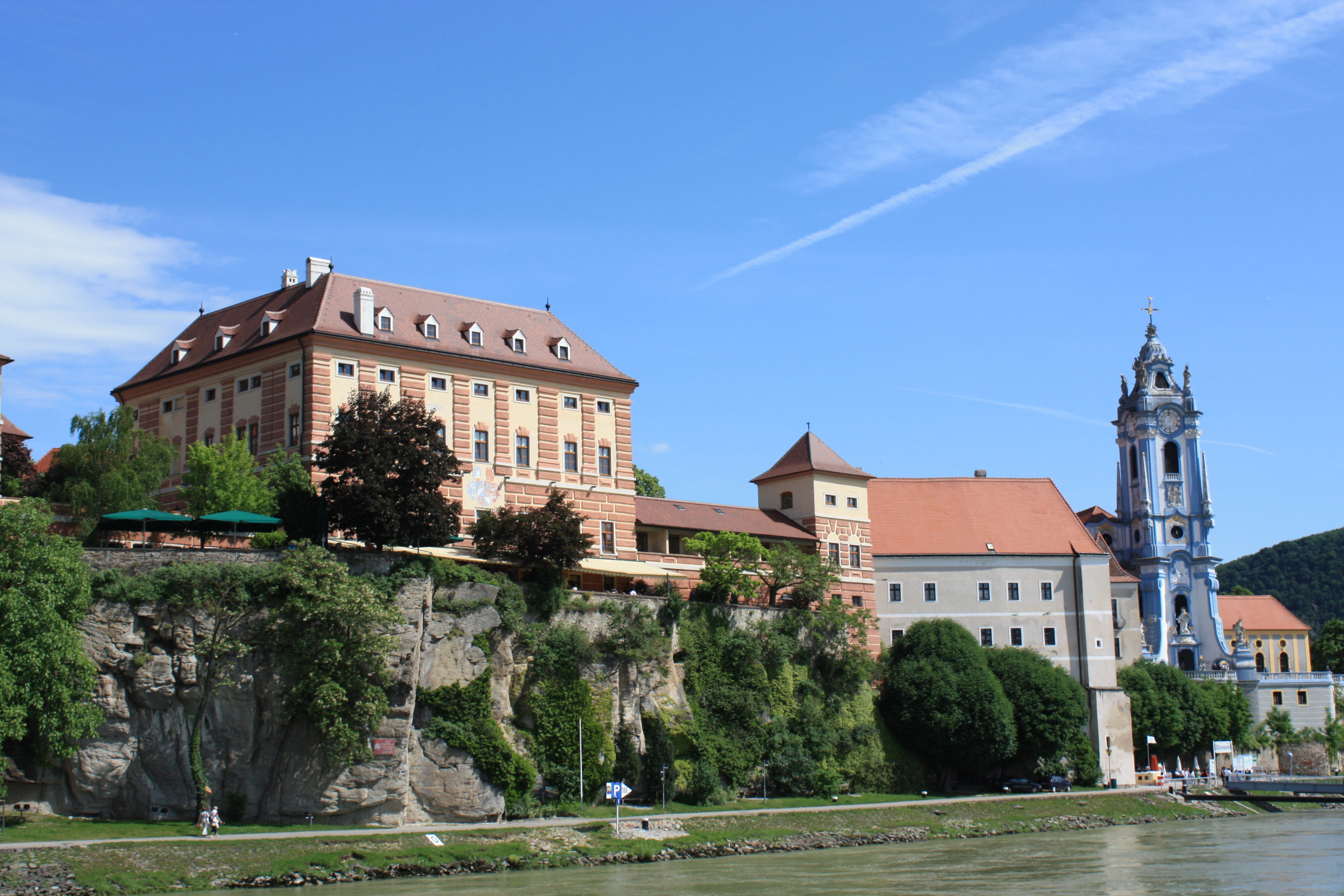 a large building on a hill next to a body of water