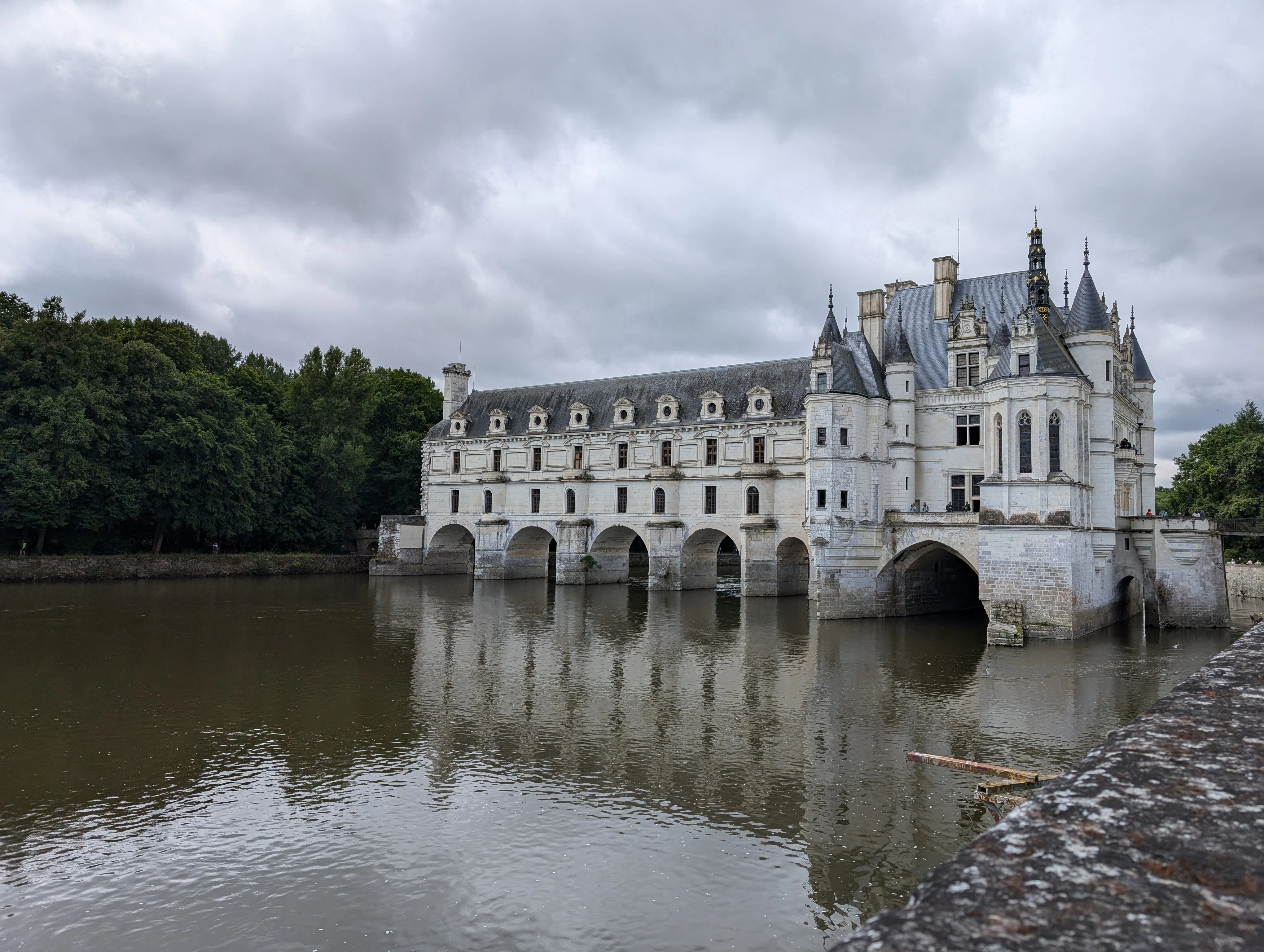 A castle sitting on top of a river next to a bridge