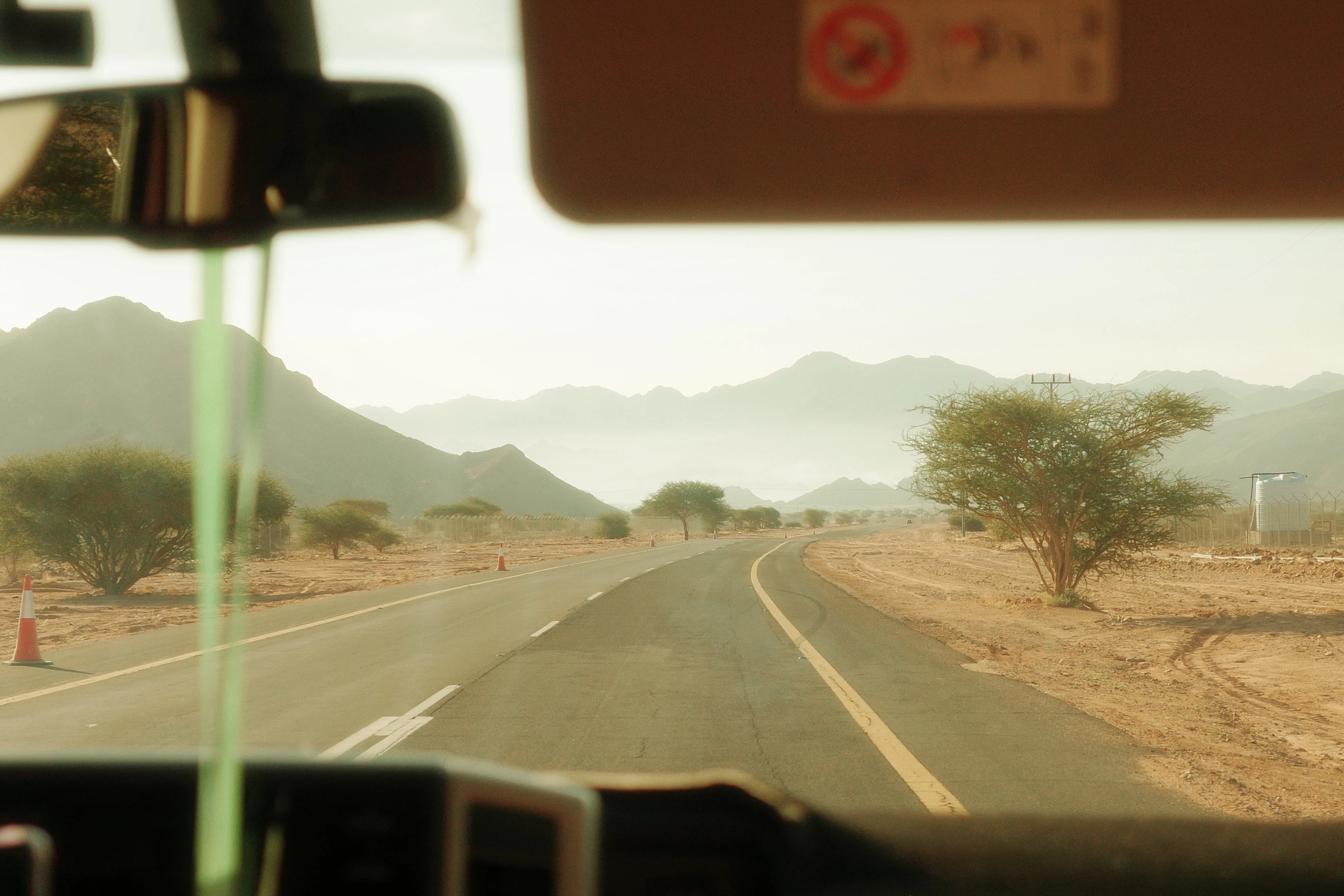 A view from inside a vehicle of a desert road
